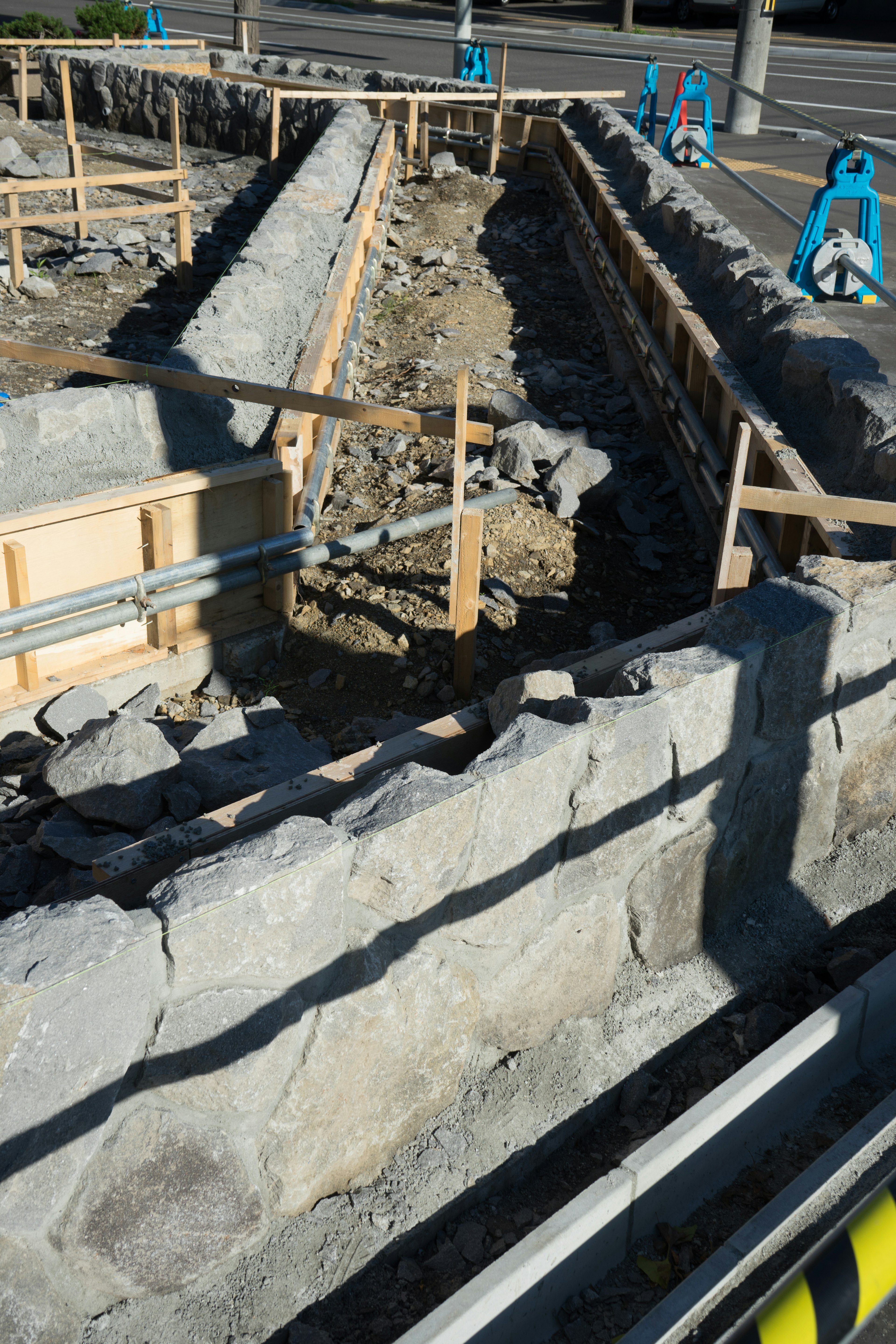 Construction site showing excavated trench with wooden supports