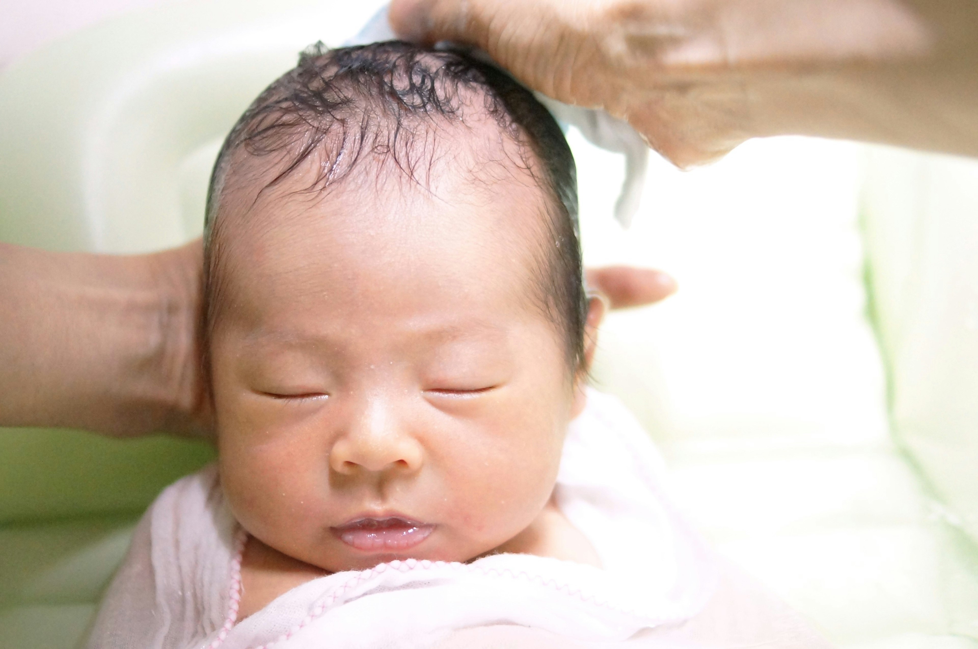 A baby having their head washed