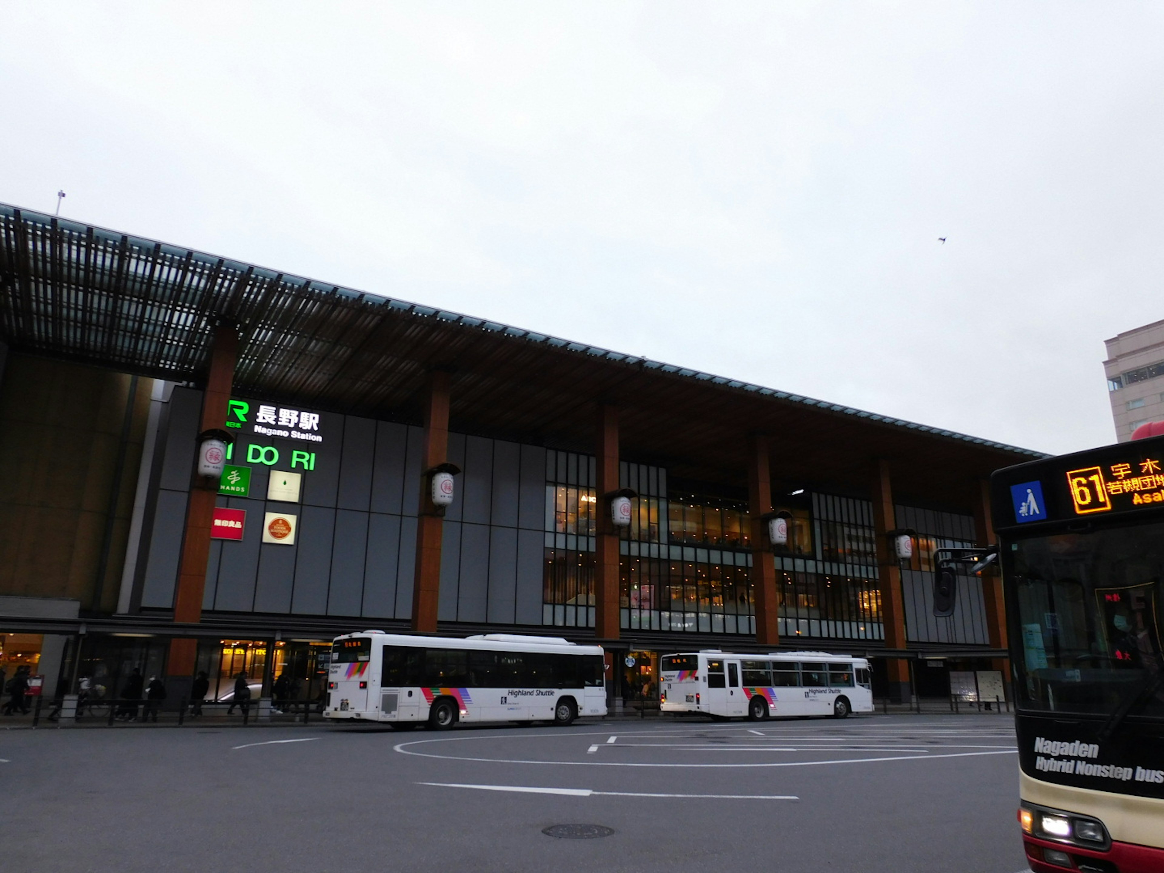 A modern train station with buses and digital signage