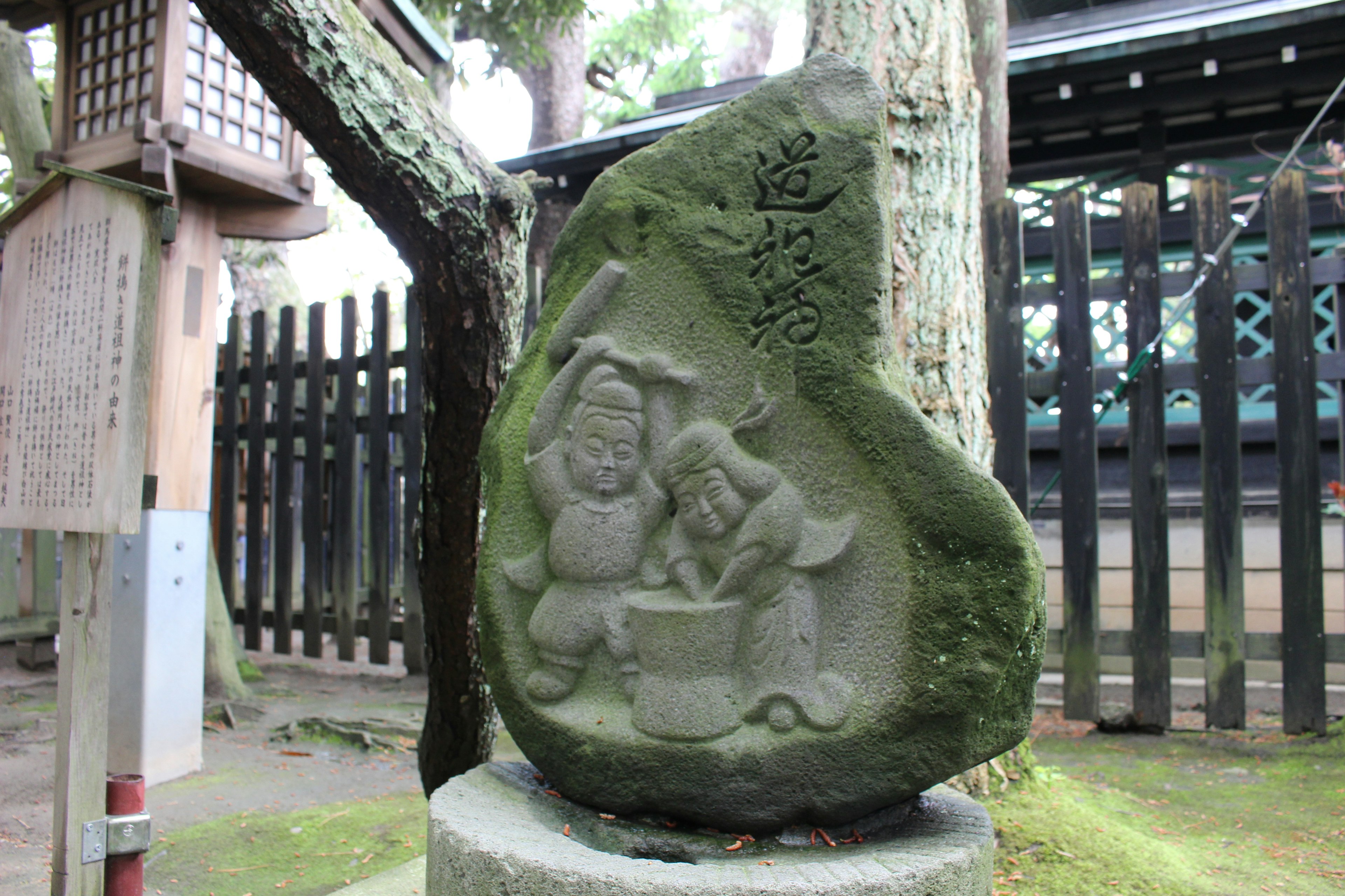 Eingravierter Stein, der zwei Figuren beim Mochi machen zeigt