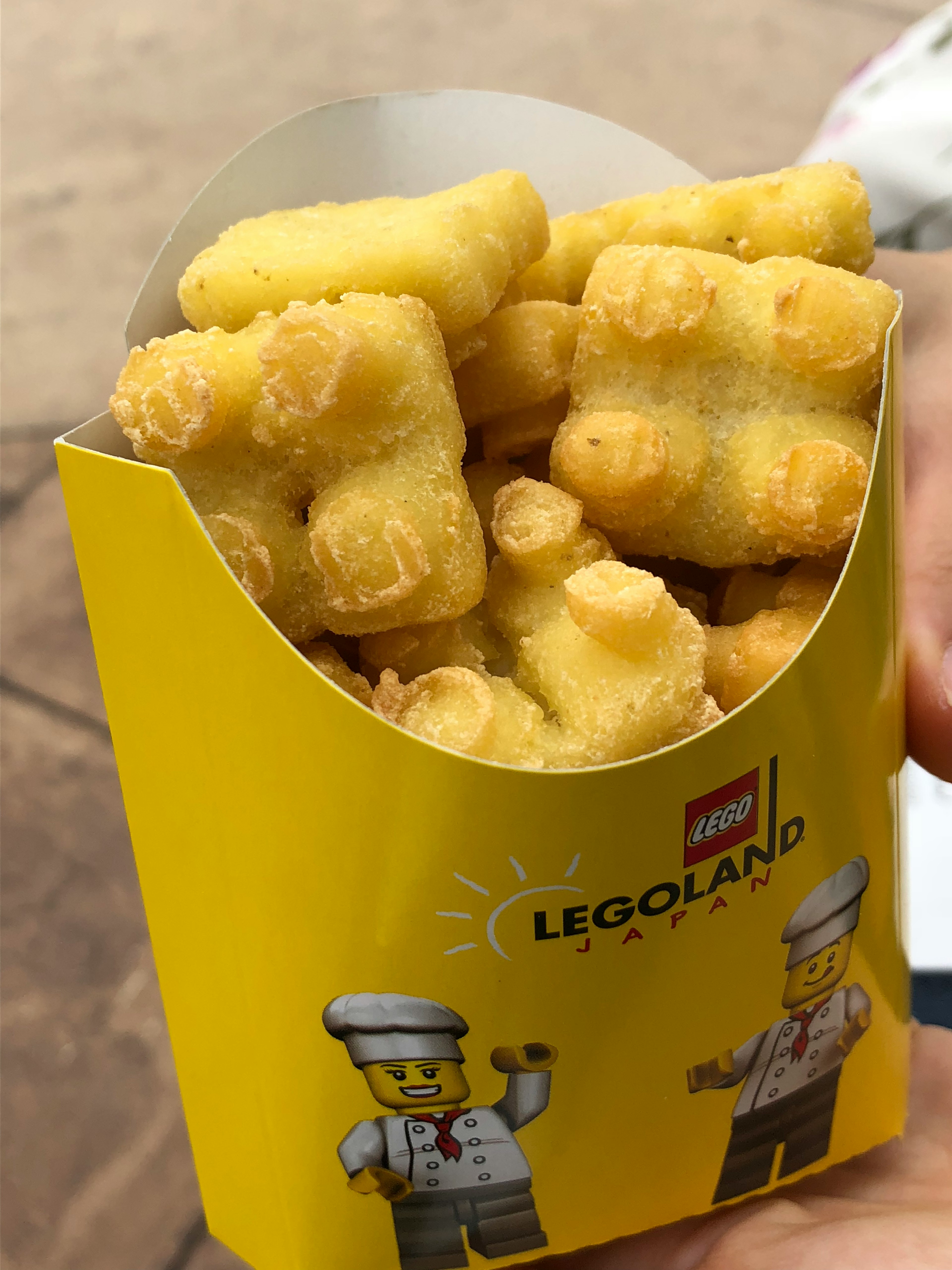 Un gobelet jaune avec le logo LEGOLAND rempli de biscuits en forme d'ours