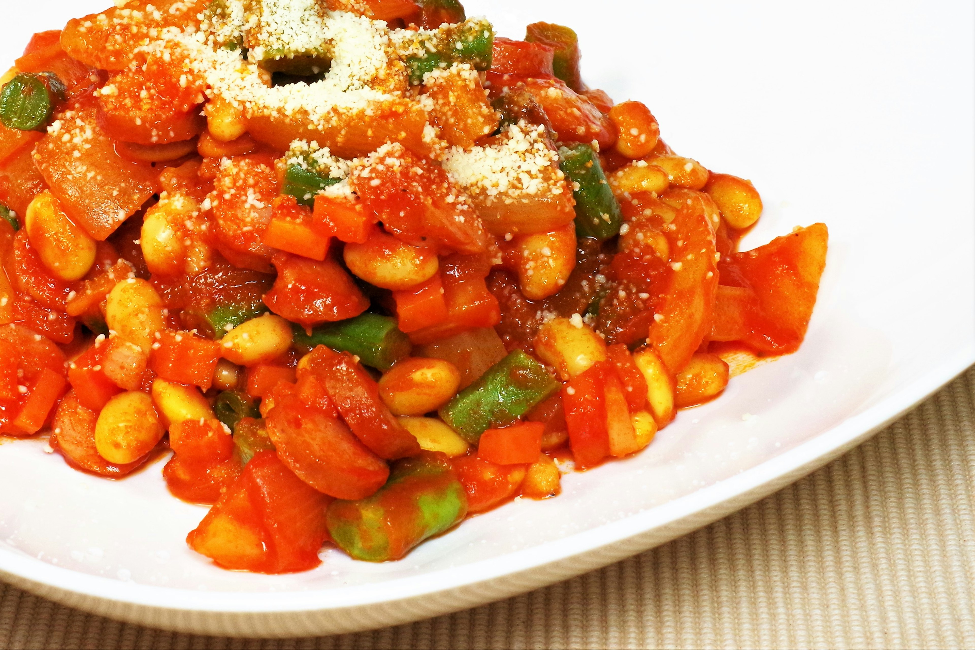 Dish featuring tomato sauce and vegetables topped with Parmesan cheese