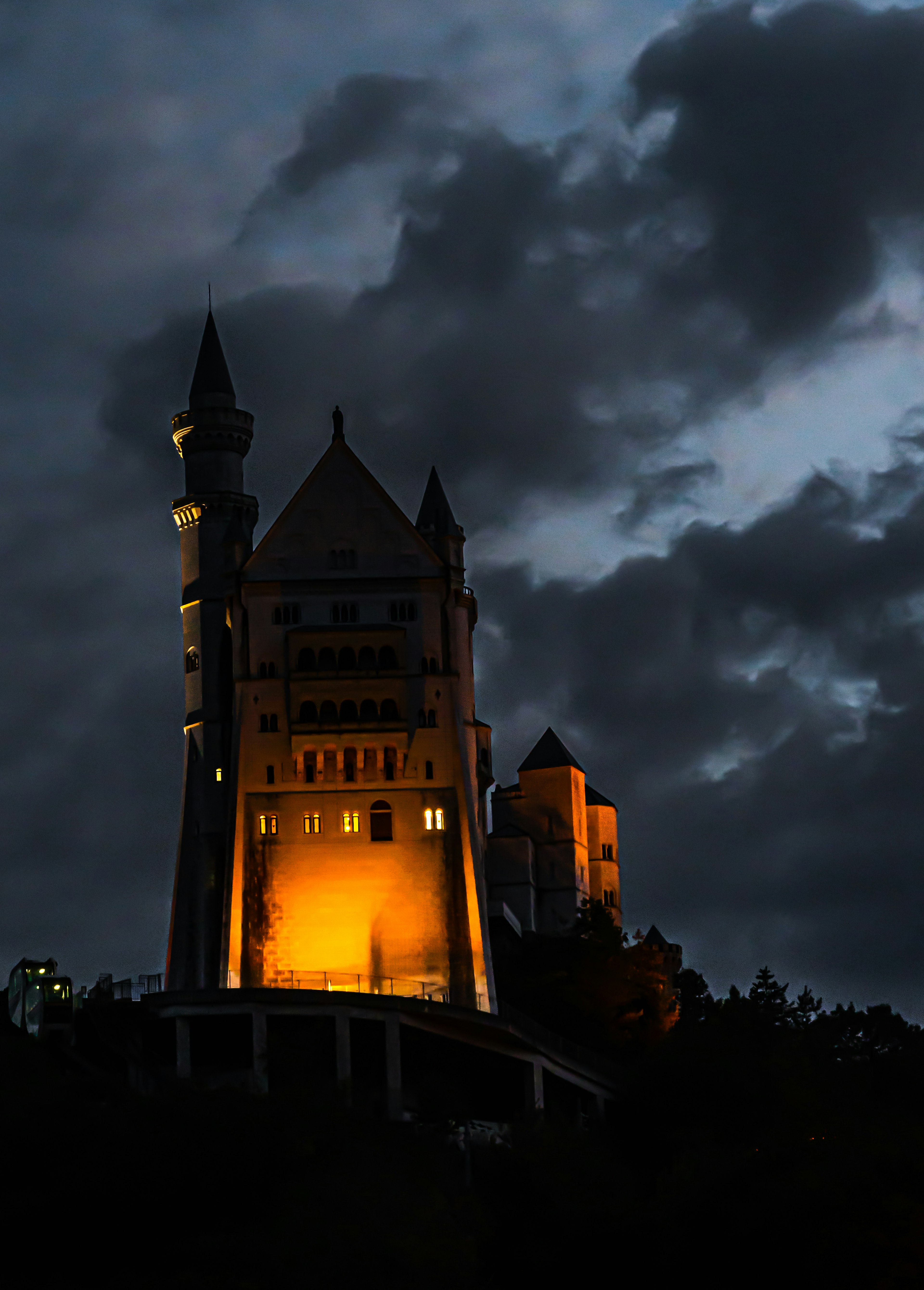 Silhouette di un bellissimo castello illuminato contro un cielo nuvoloso scuro