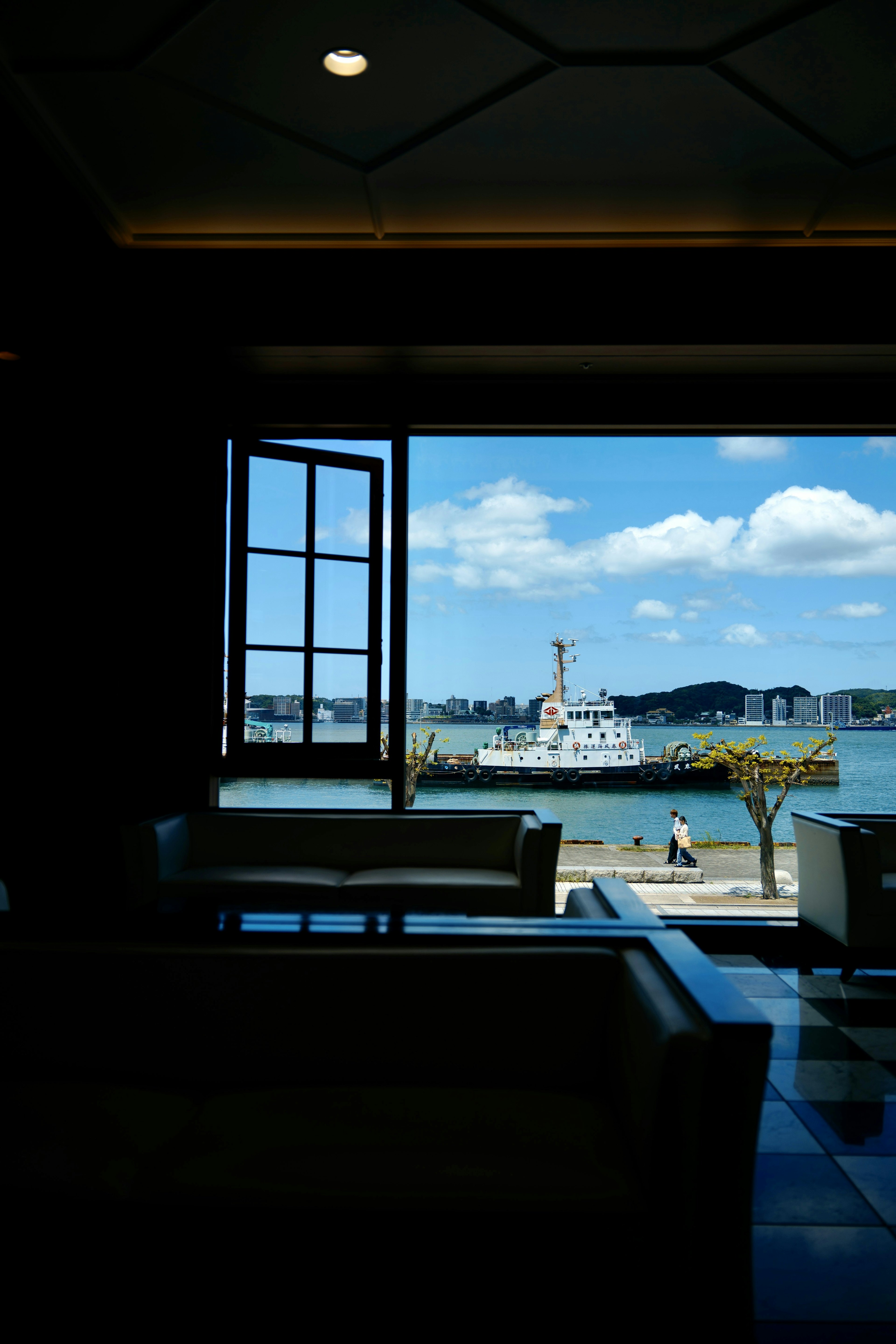 Vue sur la mer et un bateau depuis une fenêtre