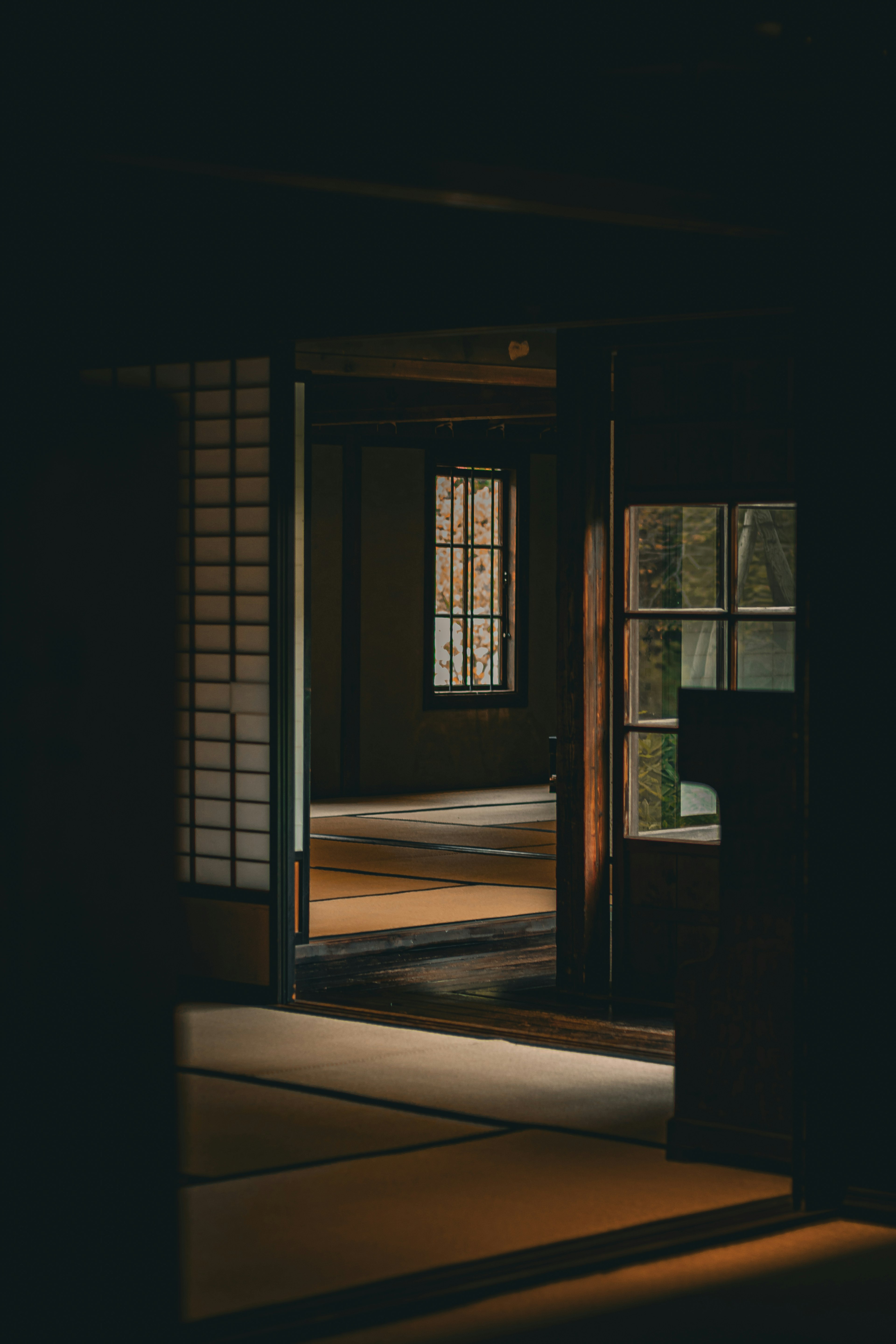 A traditional Japanese room with open doors and shoji screens in a dimly lit setting