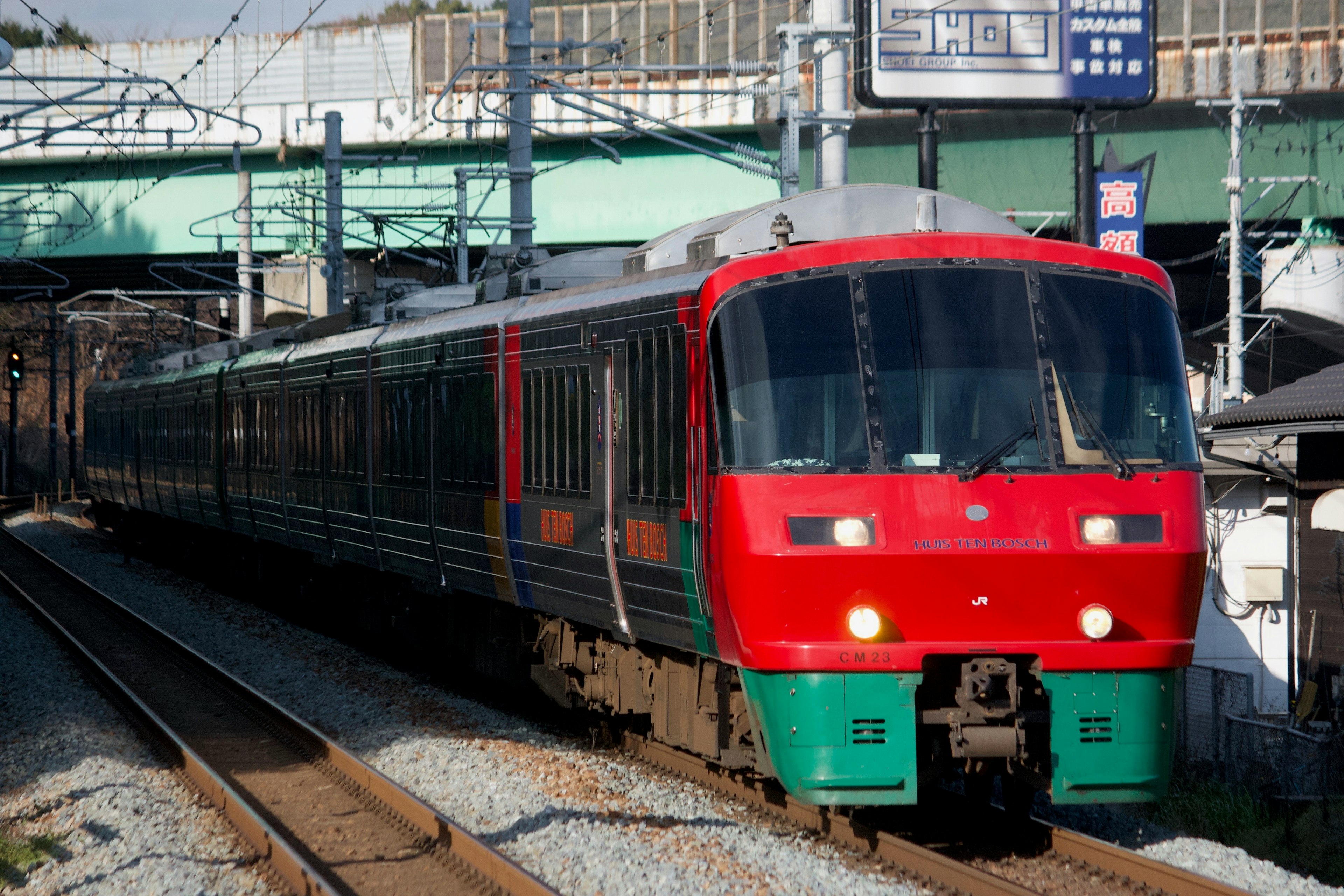 Roter und grüner Zug fährt auf den Gleisen