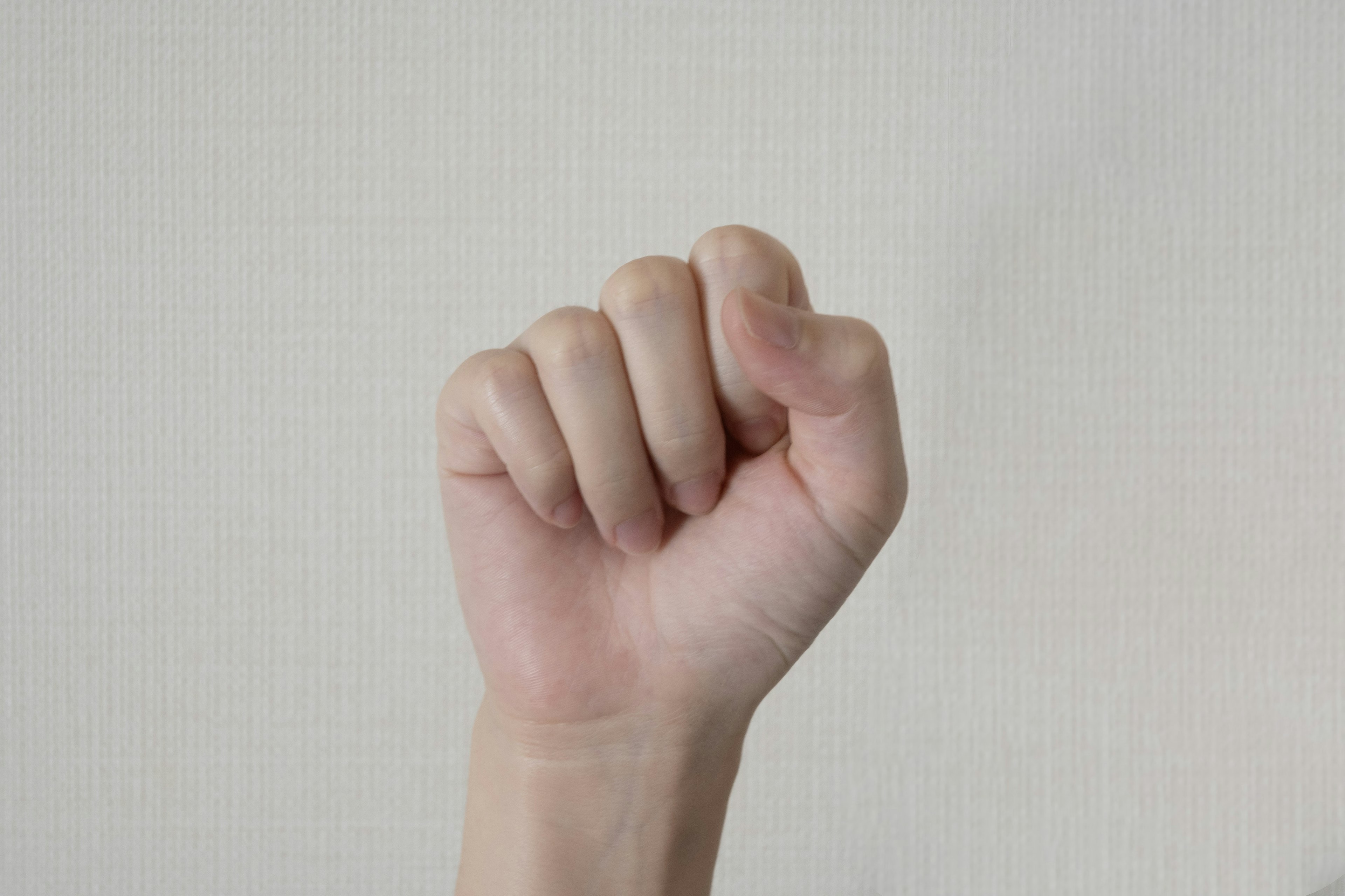 Eine Hand mit einer geballten Faust vor einem weißen Hintergrund