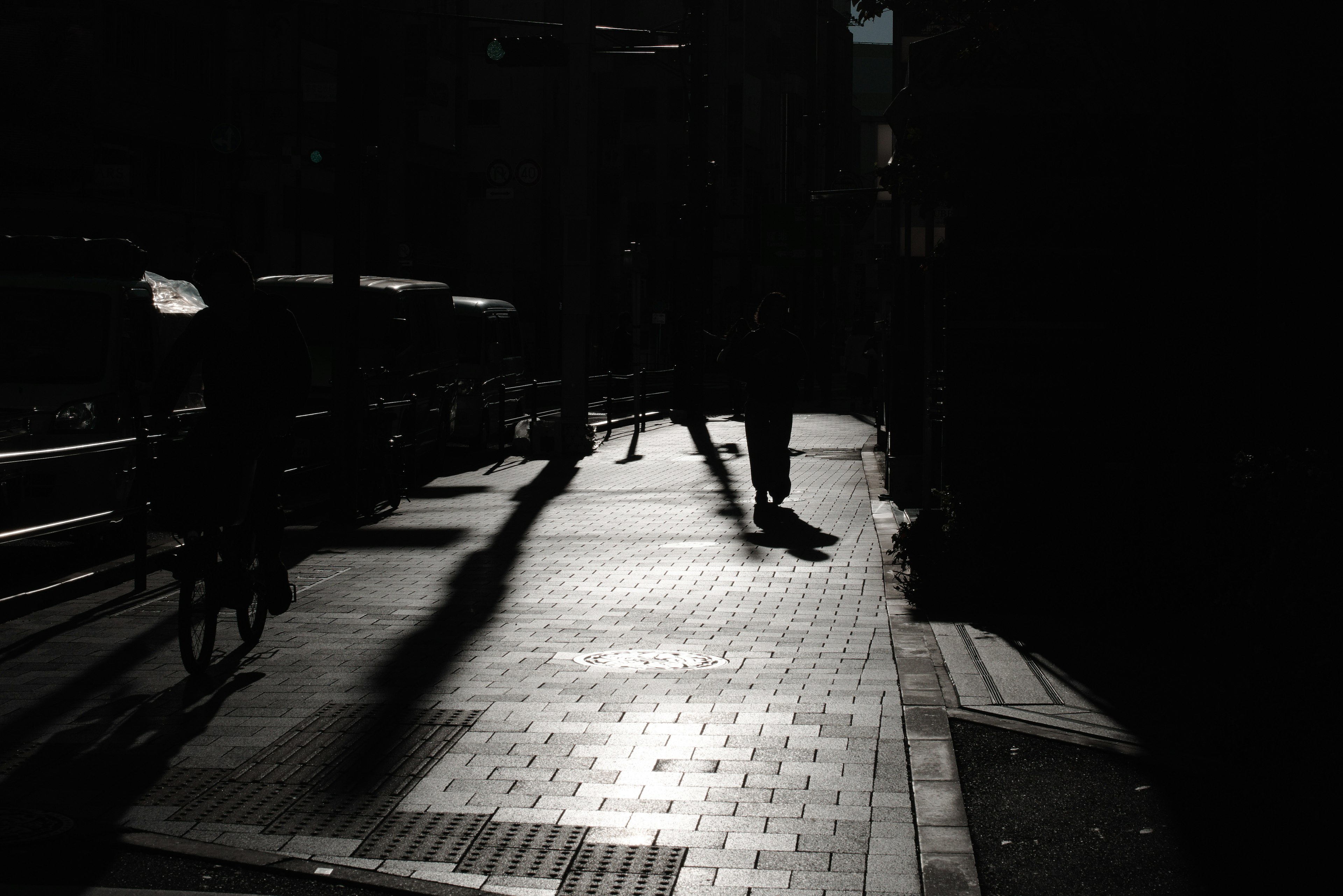 Silhouettes of people walking on a dimly lit street