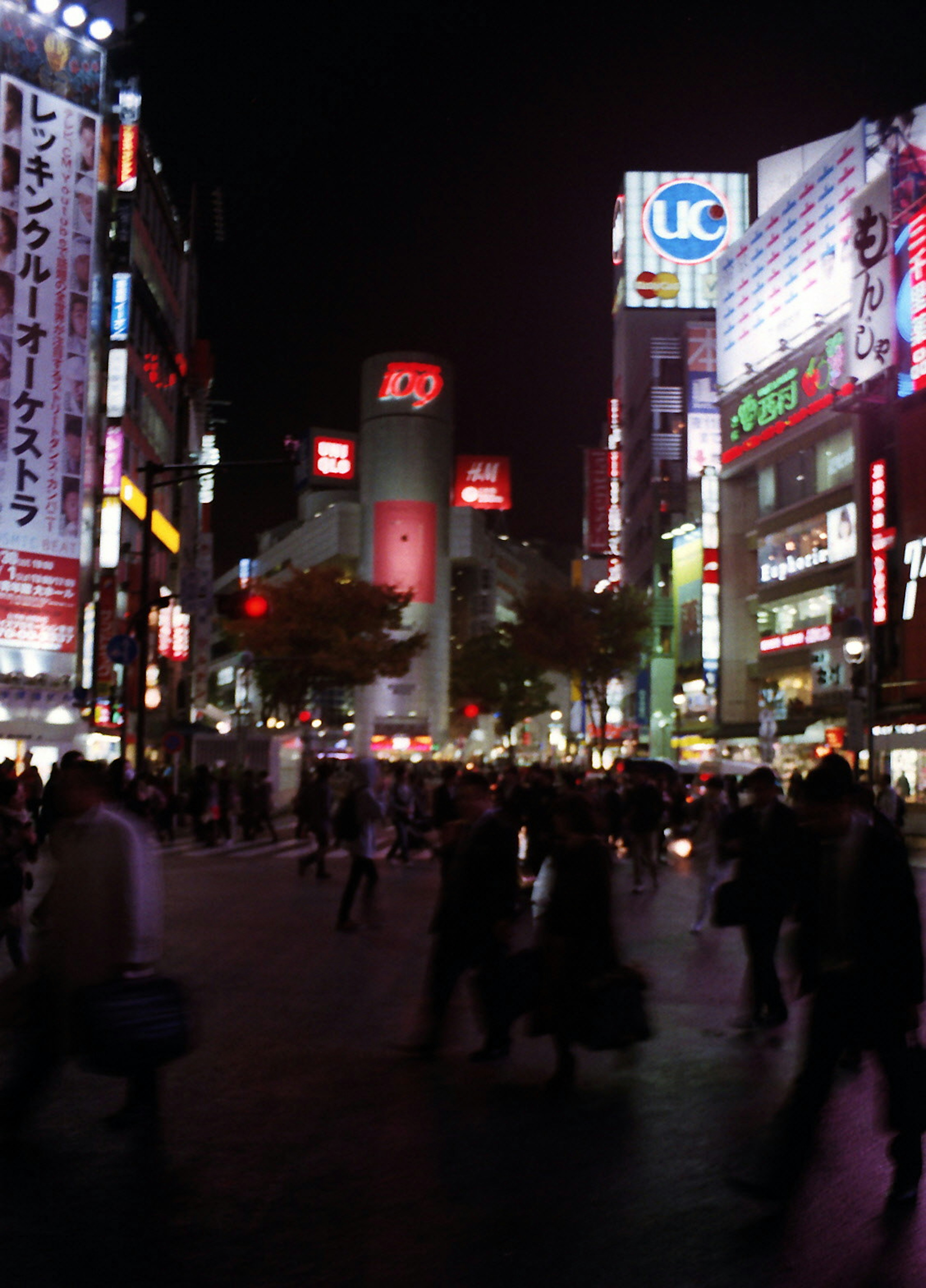 Belebte Shibuya-Kreuzung bei Nacht mit lebhaften Neonlichtern