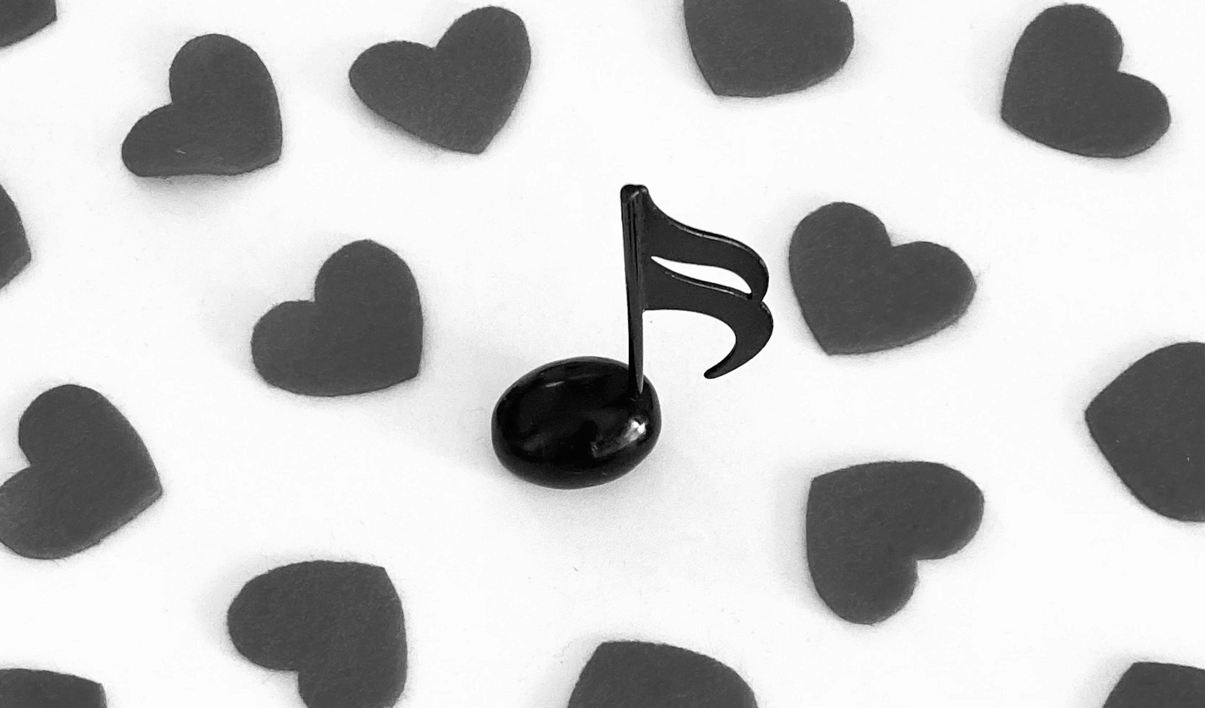 Black musical note surrounded by heart shapes