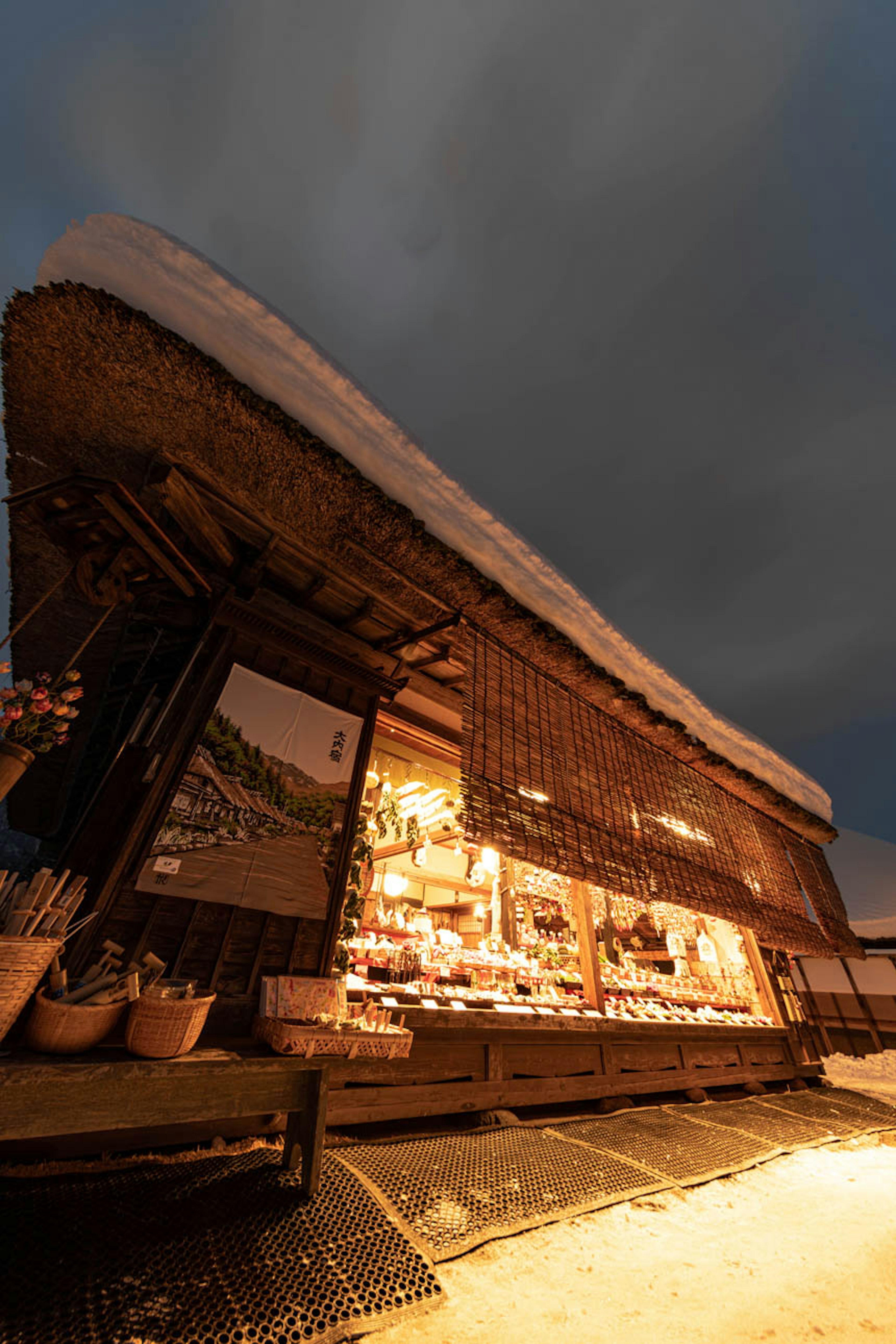 Traditional building covered in snow with warm light illuminating the interior