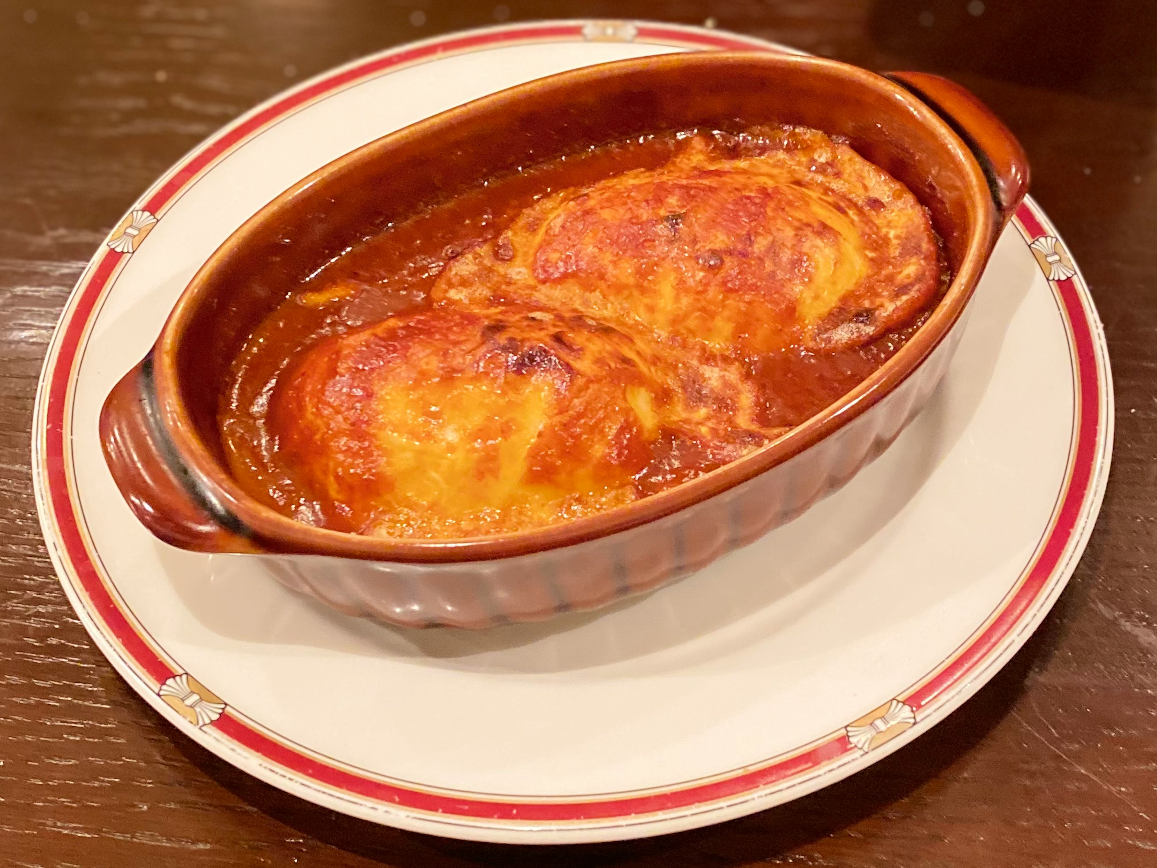 Piatto al forno con formaggio e salsa servito in una ciotola di ceramica