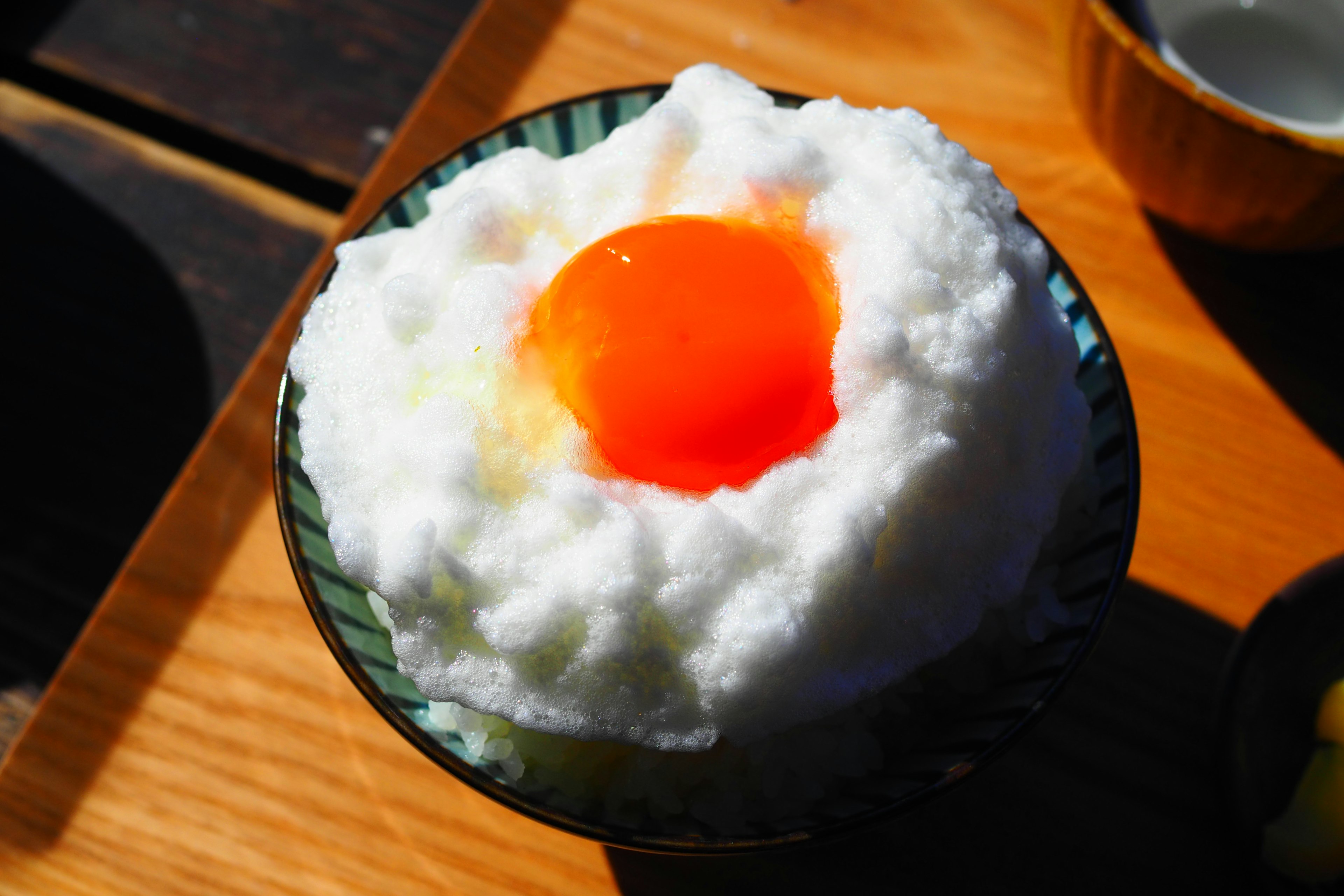 Dessert avec de la crème blanche moelleuse surmontée d'un jaune d'œuf orange vif