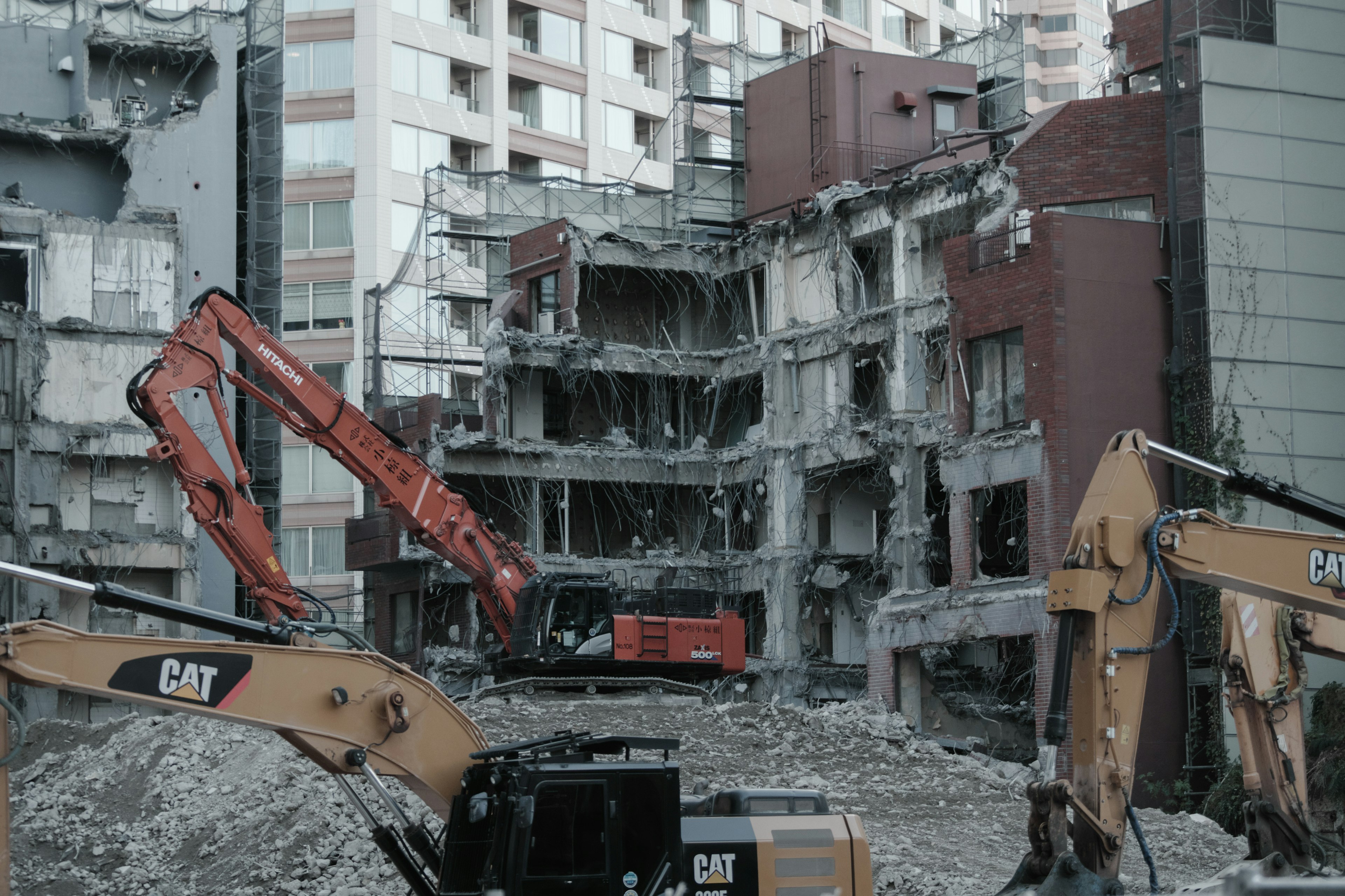 Site de démolition avec des machines lourdes travaillant sur un bâtiment