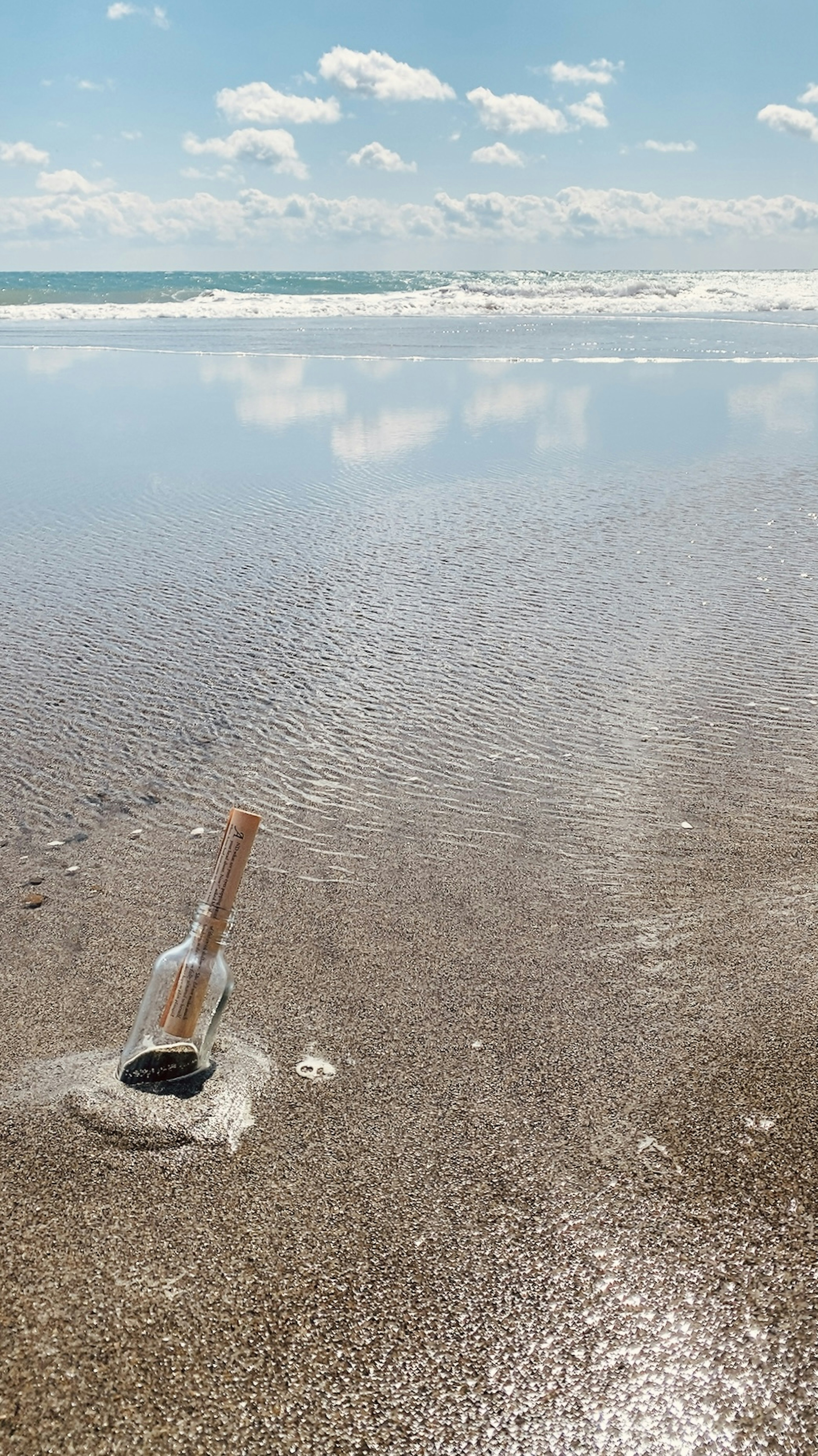 Sekop yang sebagian tertimbun di genangan air di pantai dengan langit biru