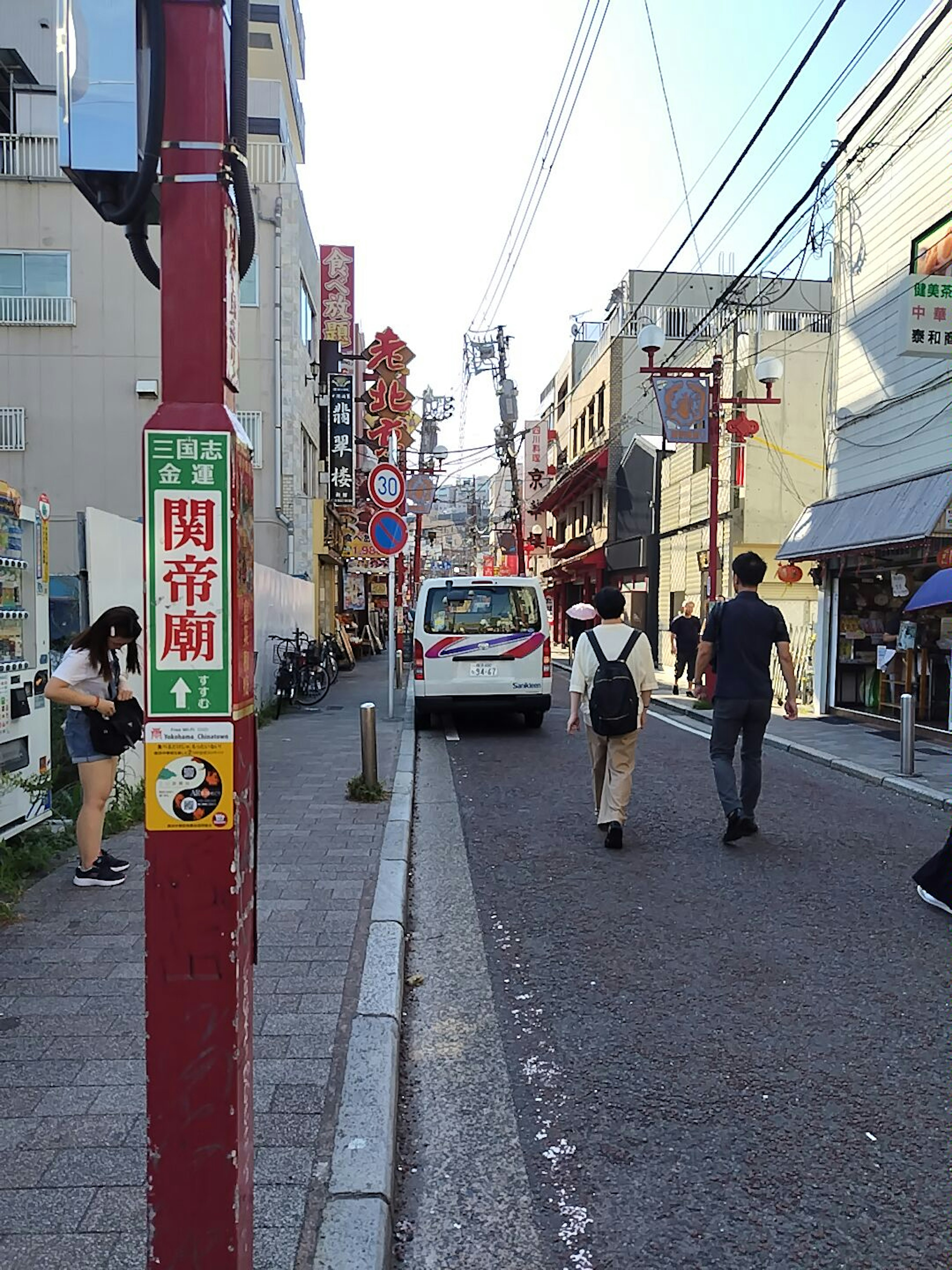 賑やかな街並みの一角で歩行者と車が行き交う風景