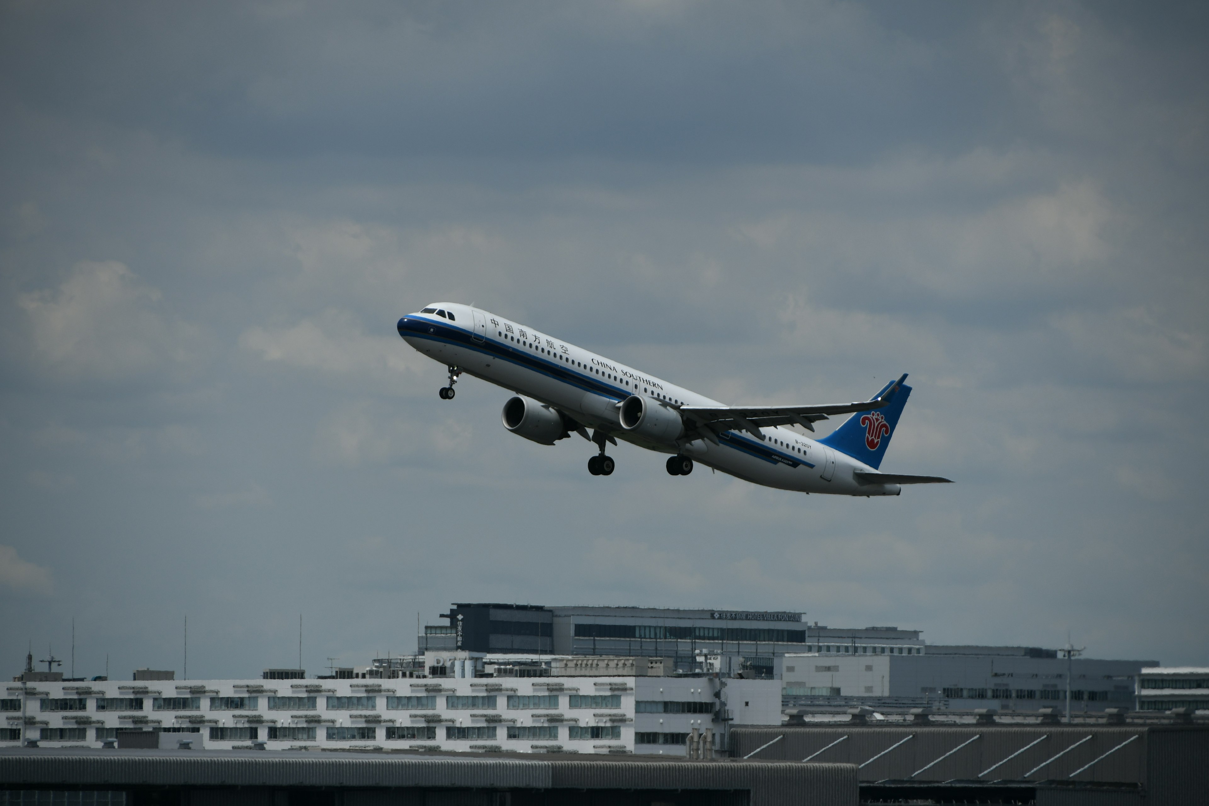 Flugzeug startet in den Himmel mit bewölktem Hintergrund