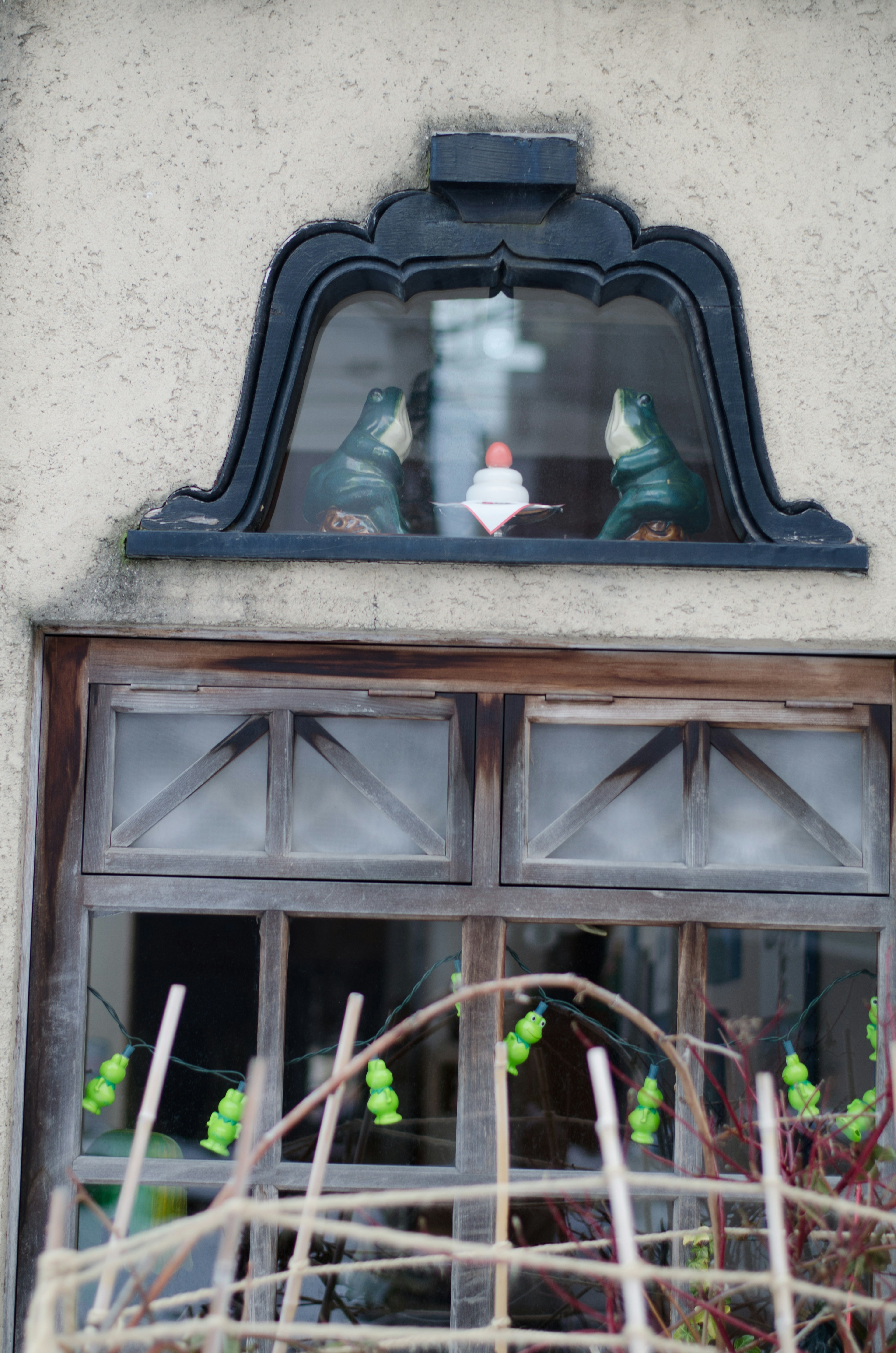 Dekorative Figuren über einem Fenster mit einem zentralen weißen Objekt