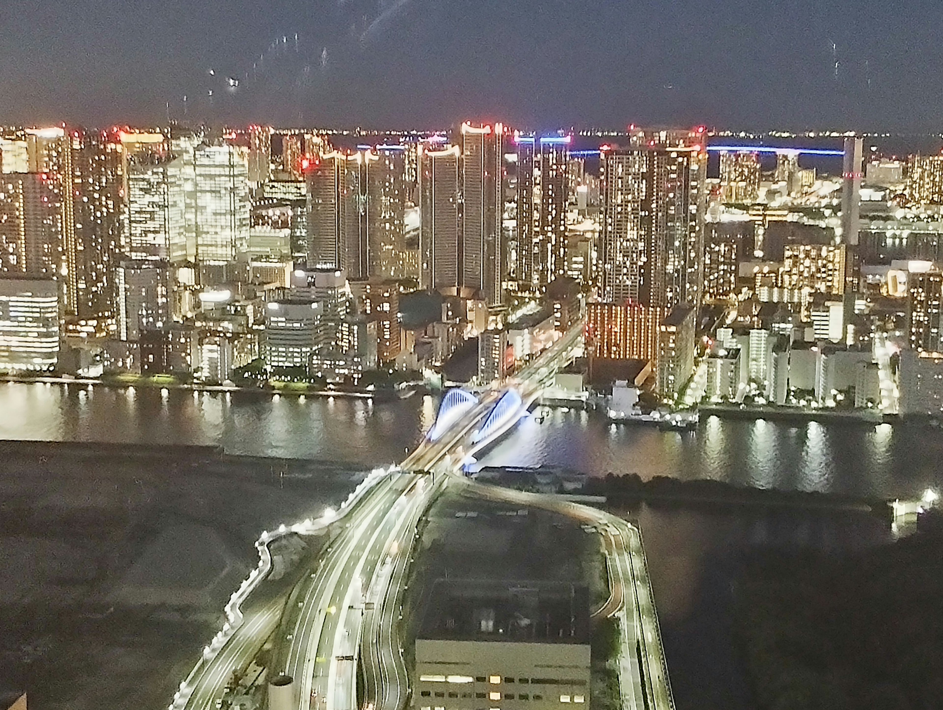 夜の東京の高層ビル群と明るい街灯