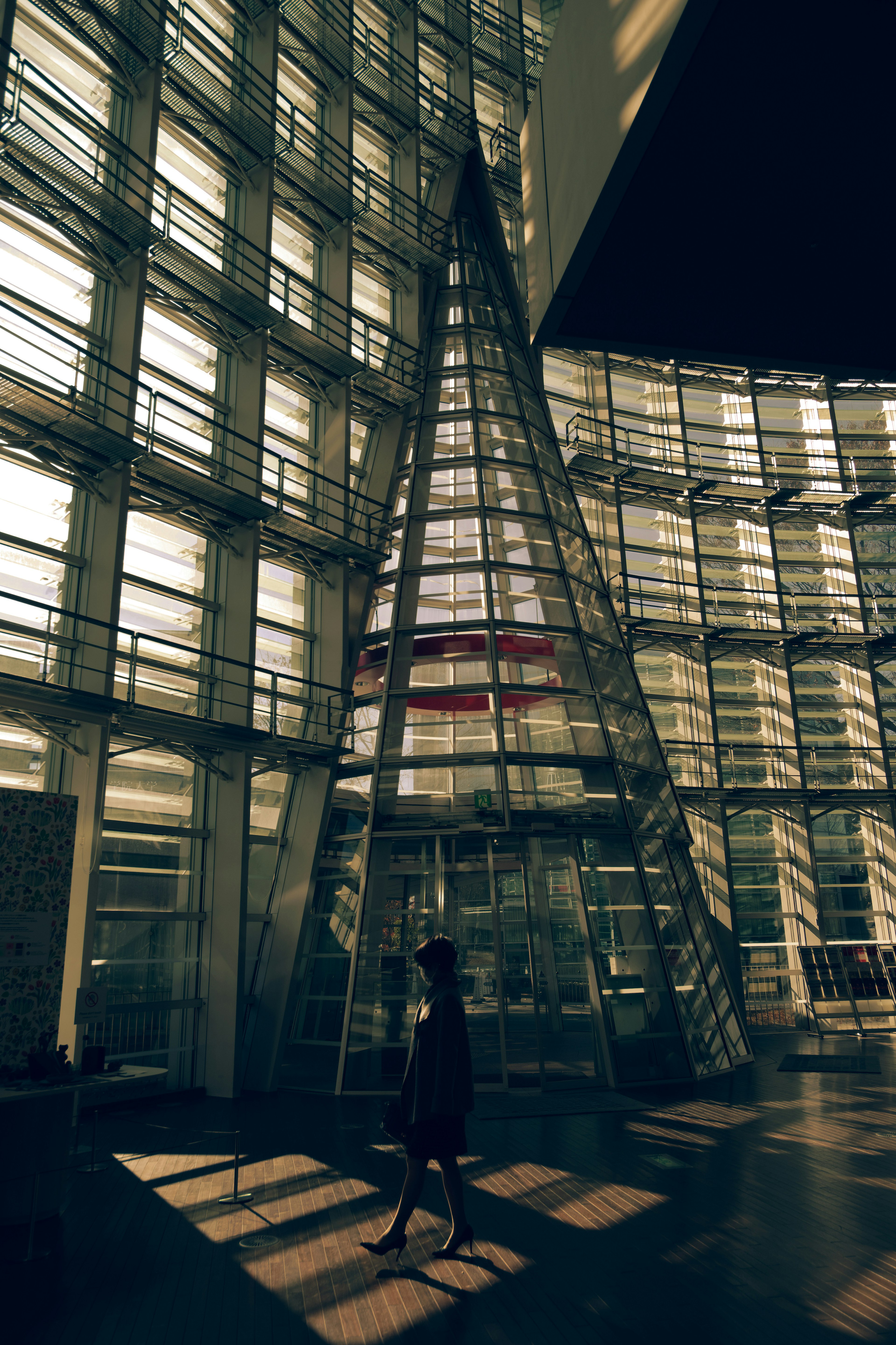 Silhouette di una persona in un edificio di vetro di notte con forme geometriche