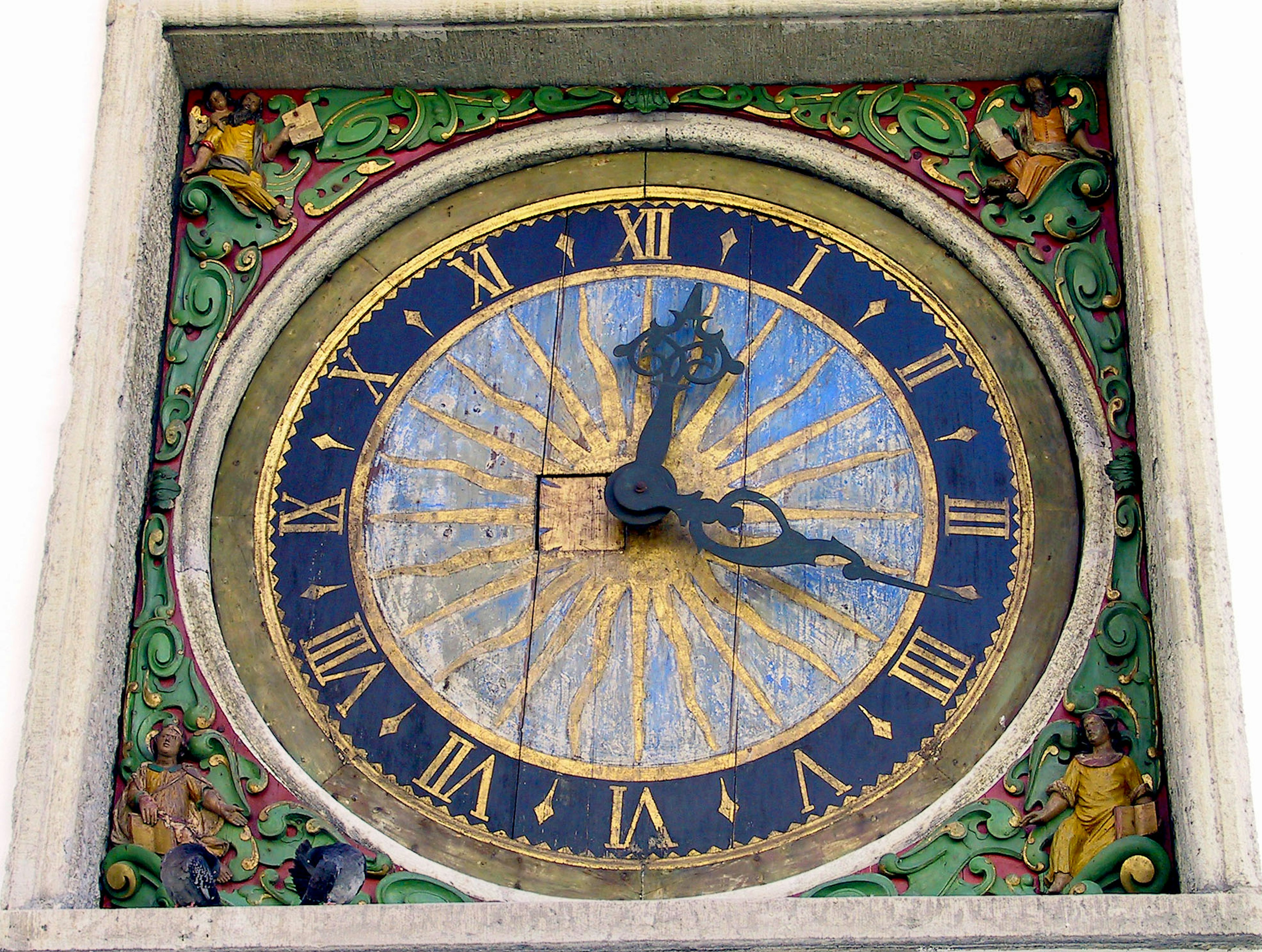 Decorative clock dial featuring blue and gold background with Roman numerals