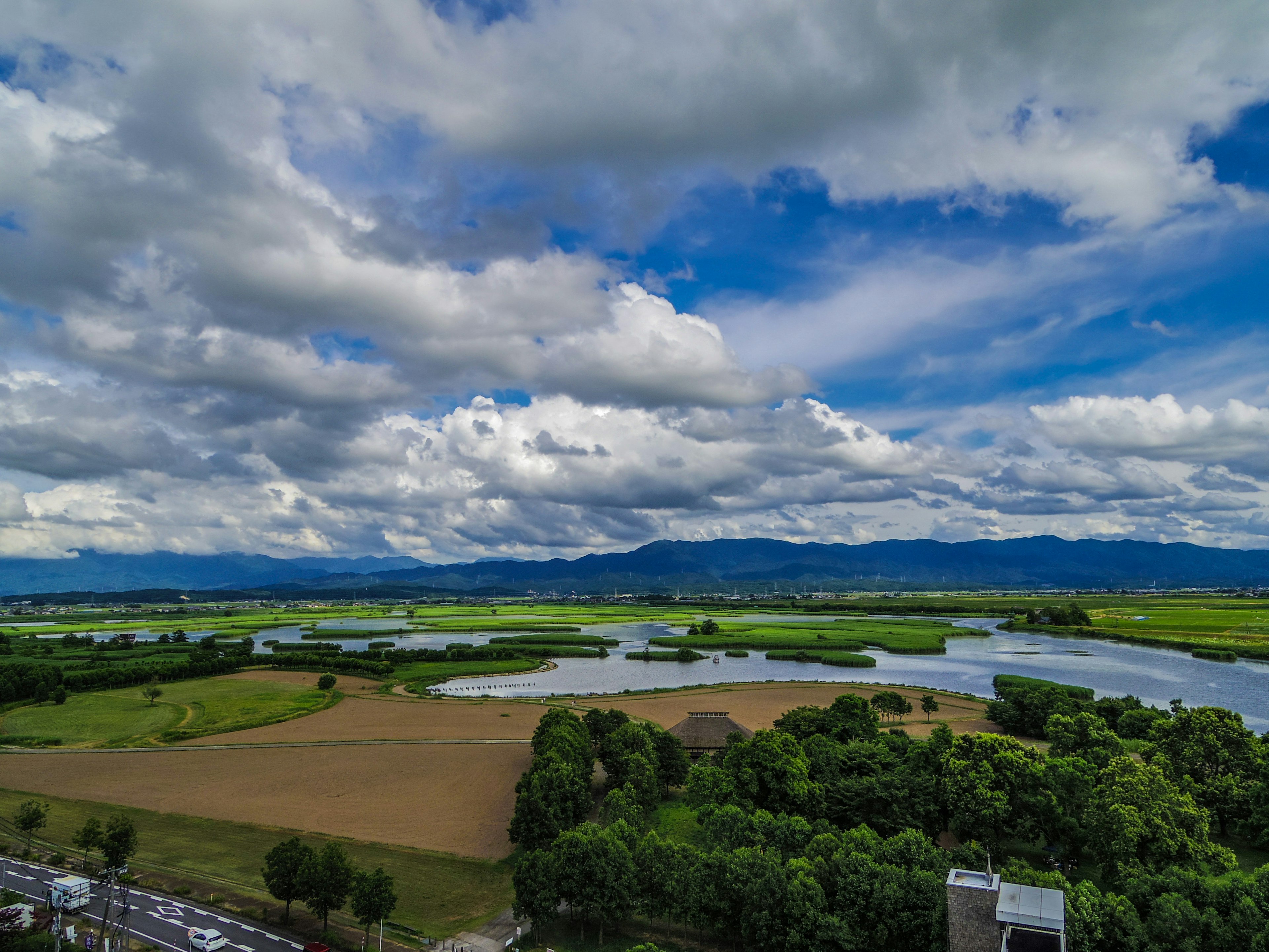 Vista panoramica di un cielo blu con nuvole bianche campi verdi e fiumi