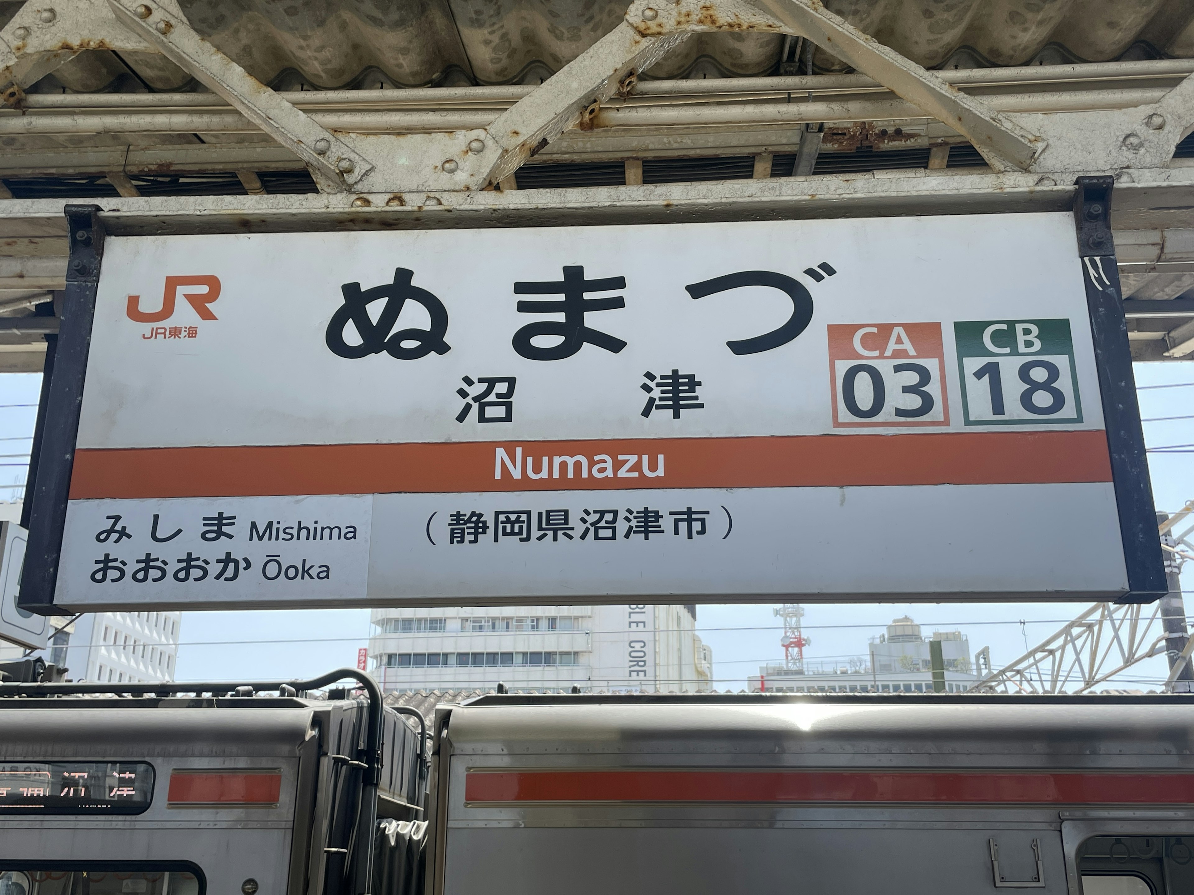 Numazu Station sign with train in view