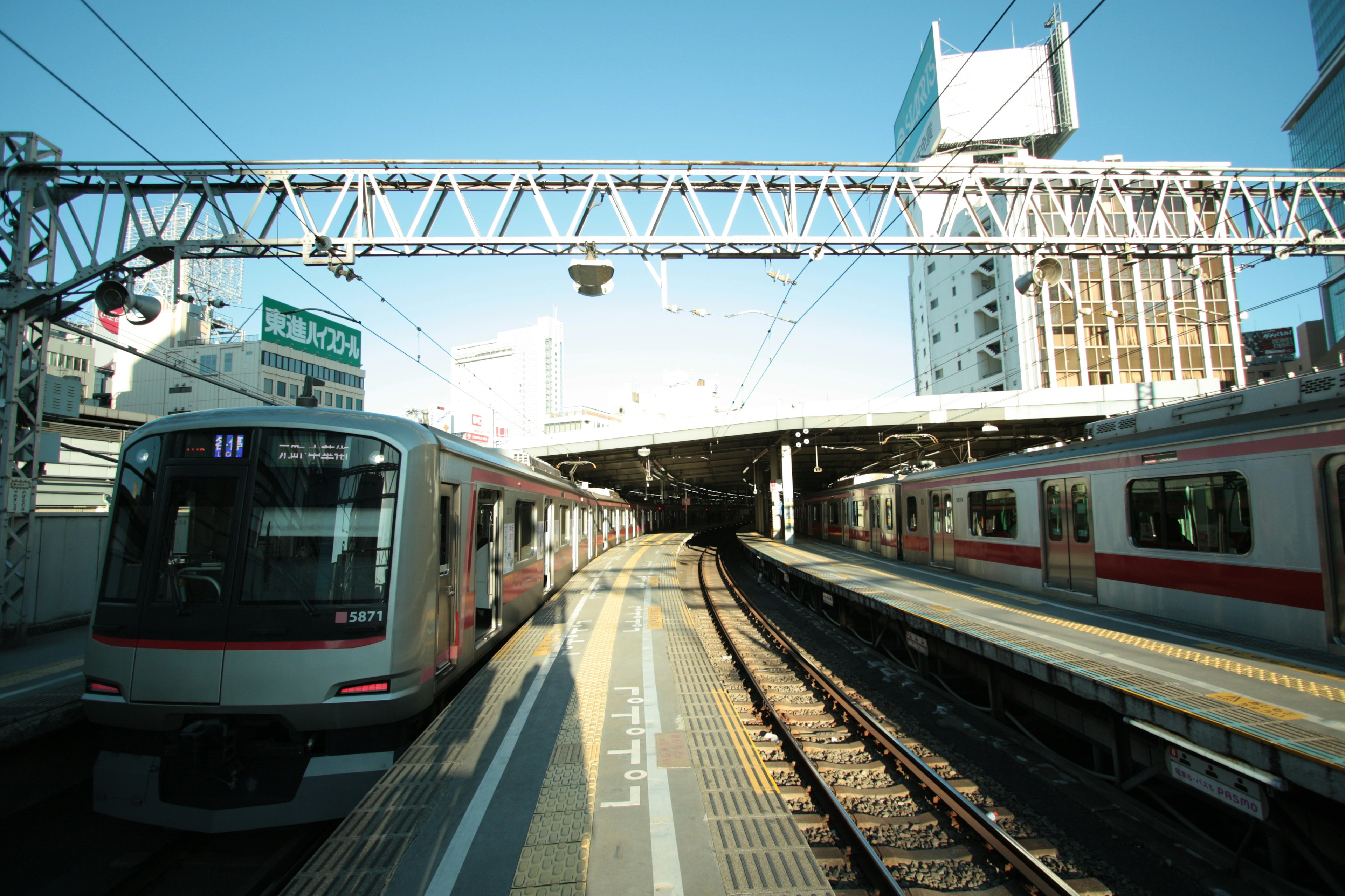 駅のホームに停車中の電車と青空