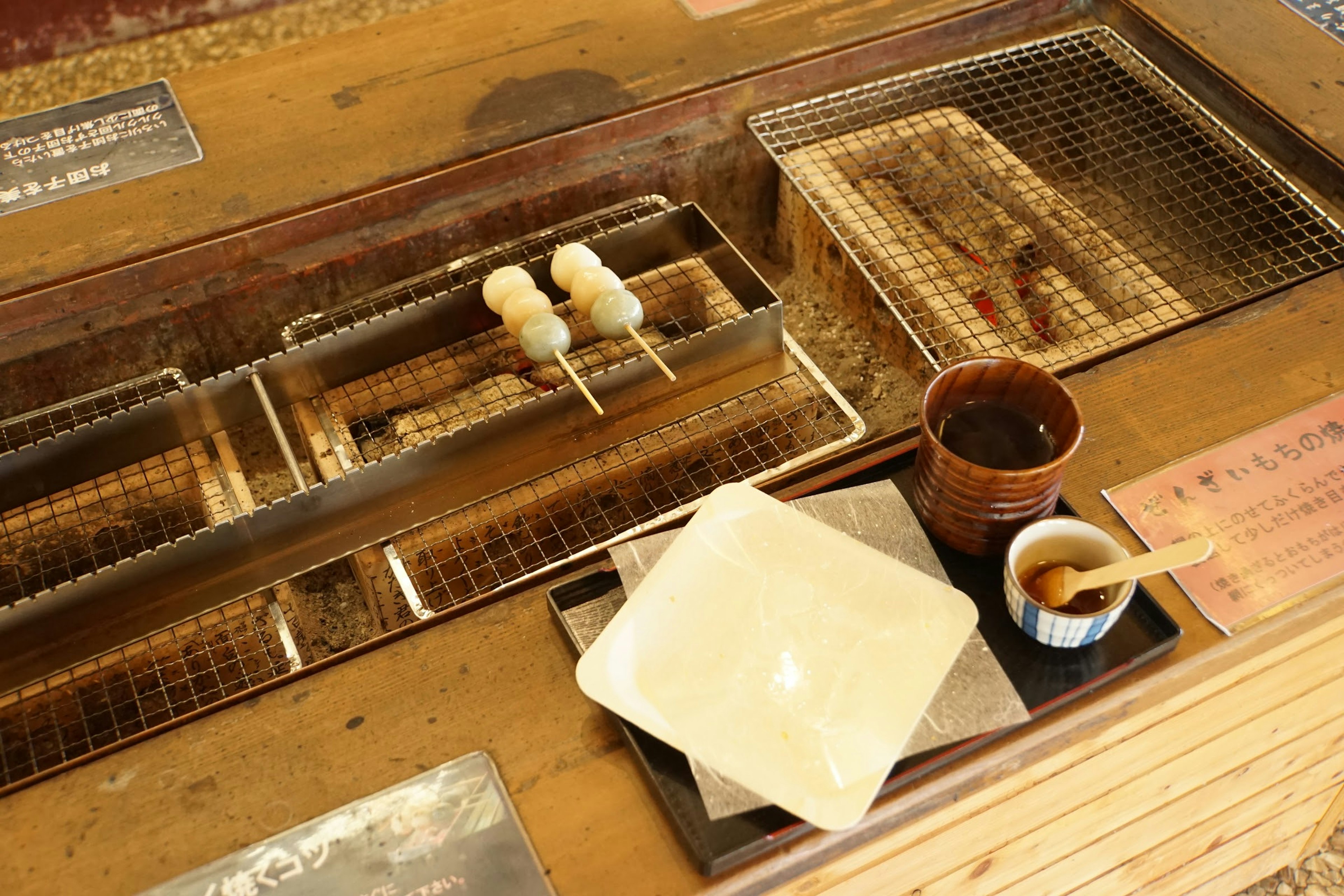 Grilled skewers and cooking utensils on a wooden table