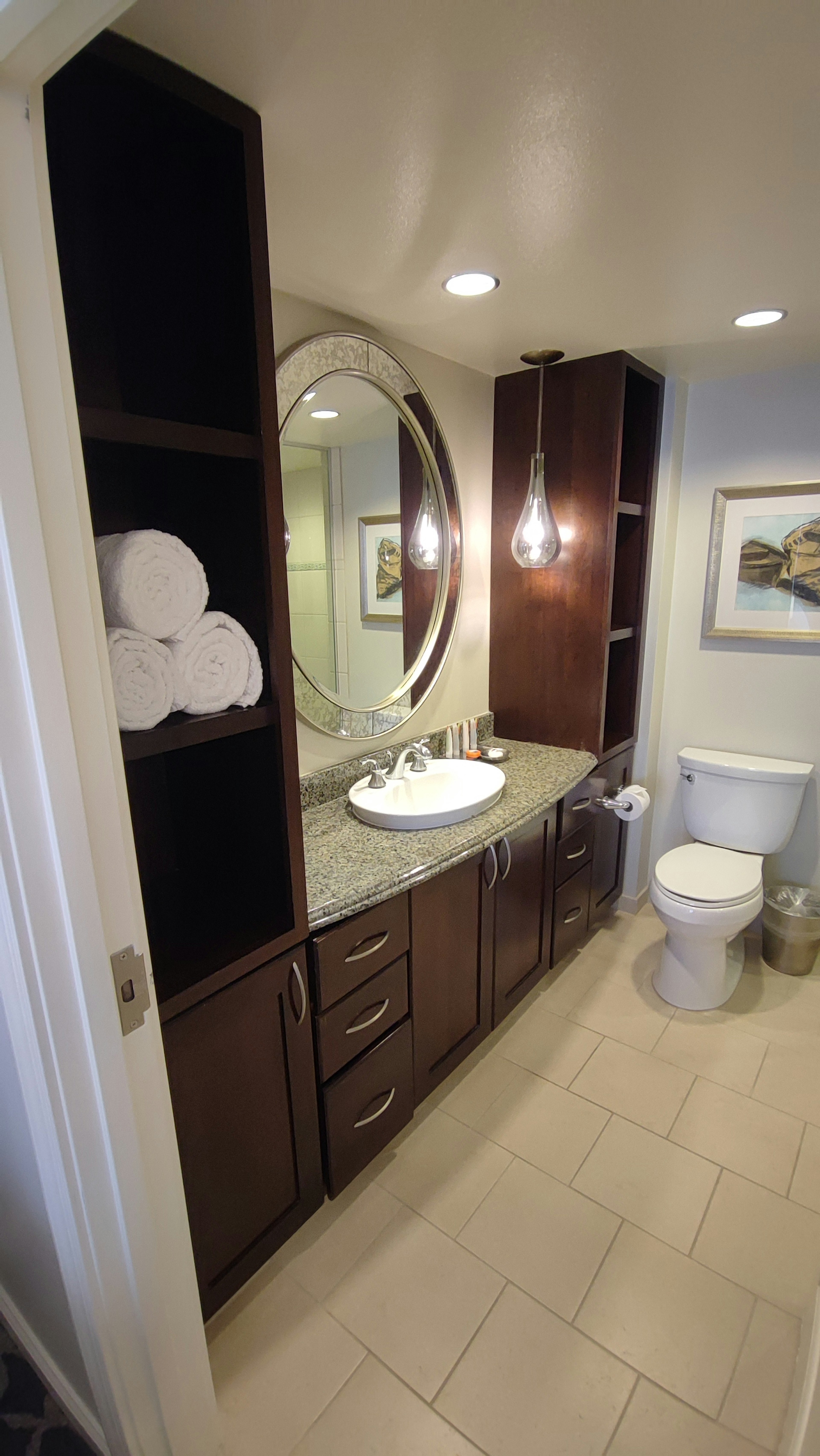 Salle de bain moderne avec lavabo et miroir rond et toilettes dans un design épuré