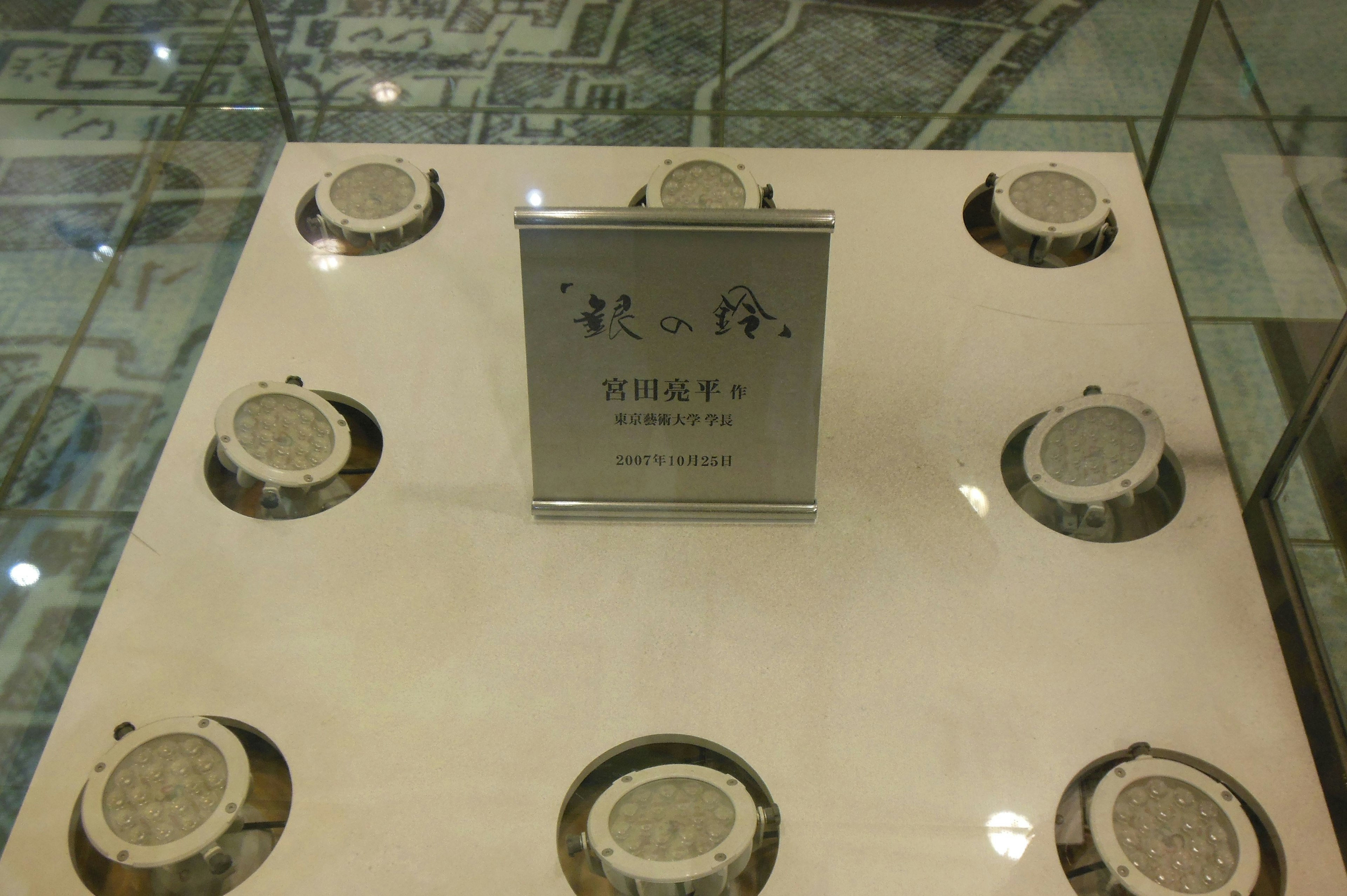 A display case with ceramic plates arranged around an information plaque