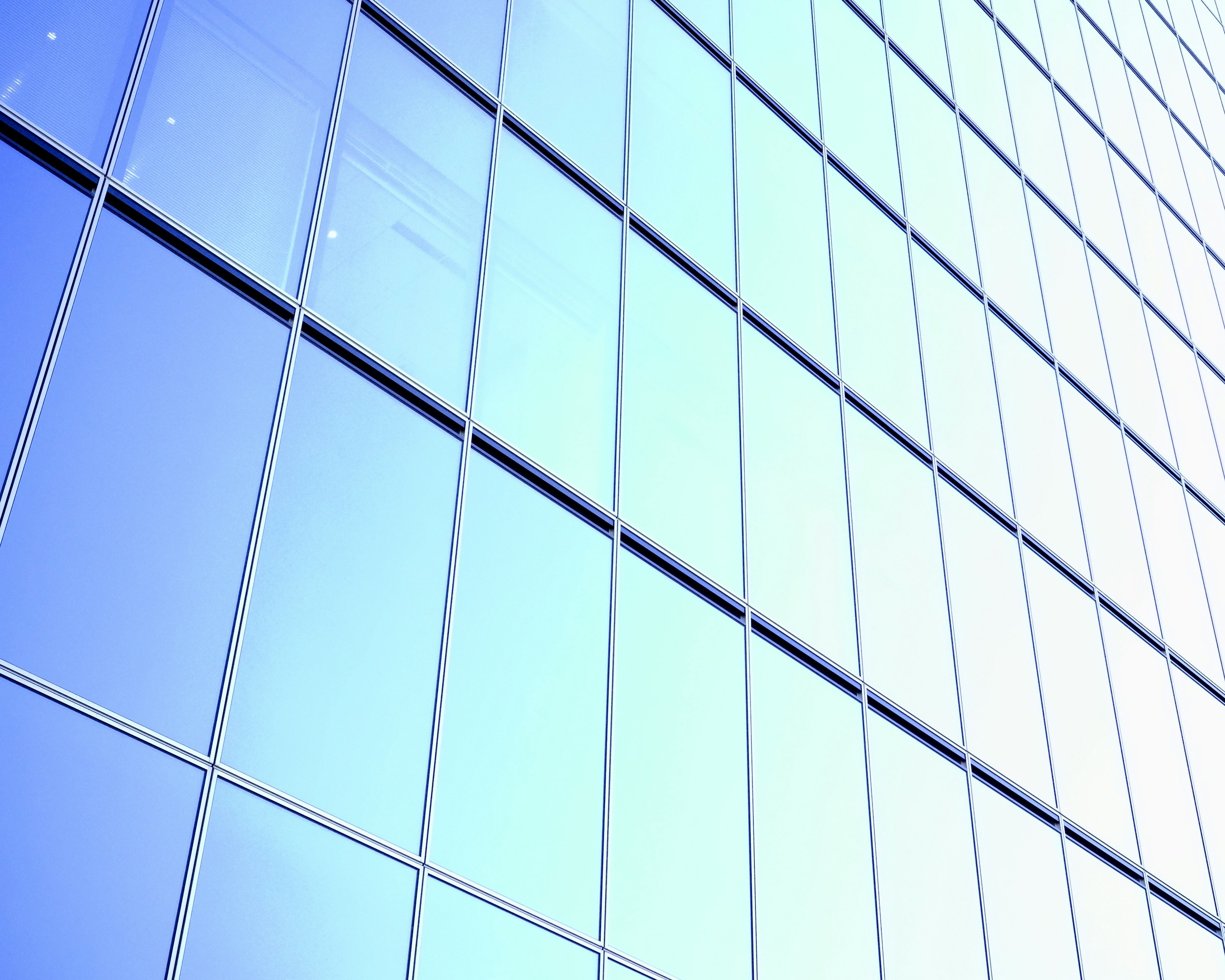 Vue diagonale d'un bâtiment moderne avec une façade en verre bleu