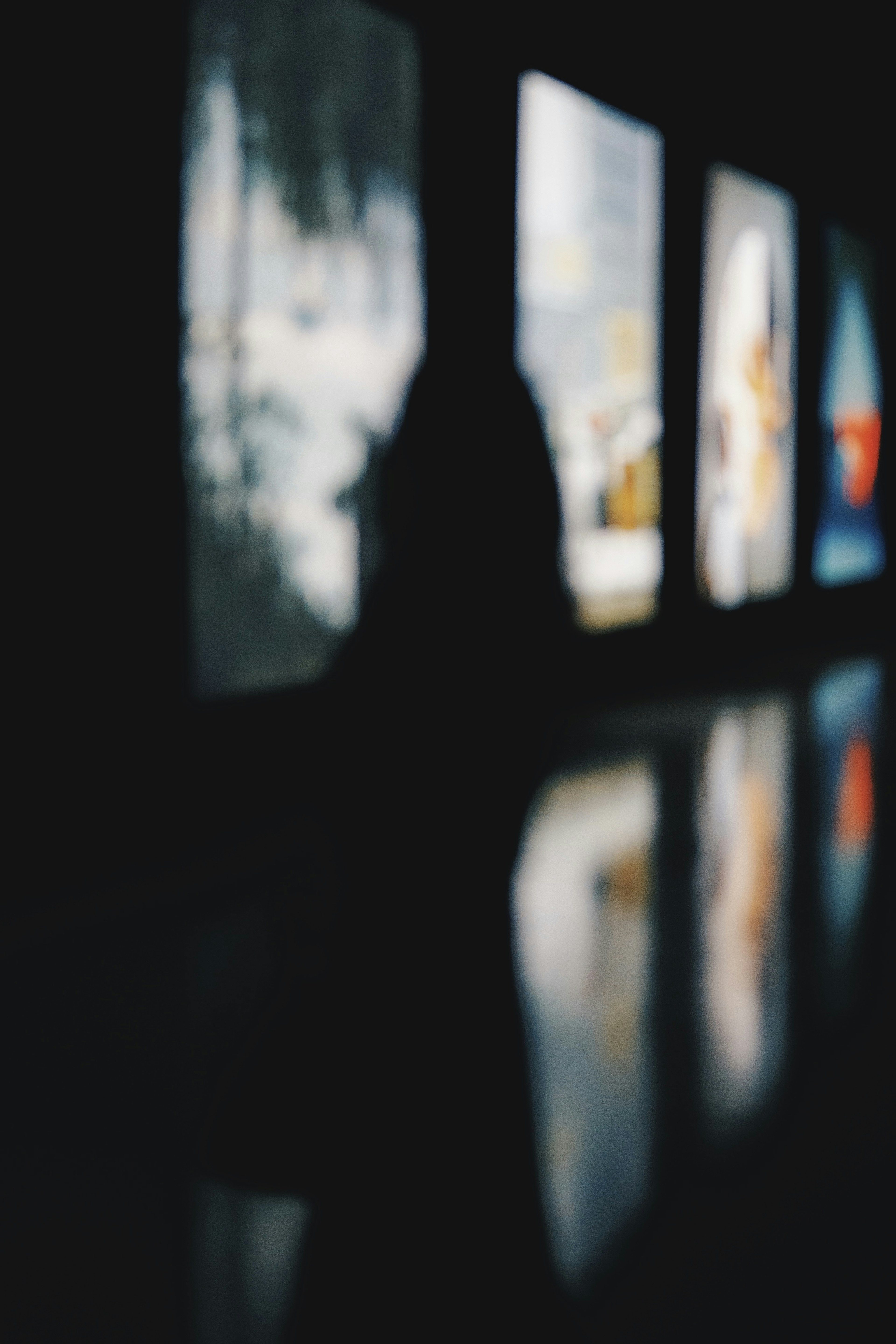 Silhouette of a person in a dimly lit room with colorful paintings