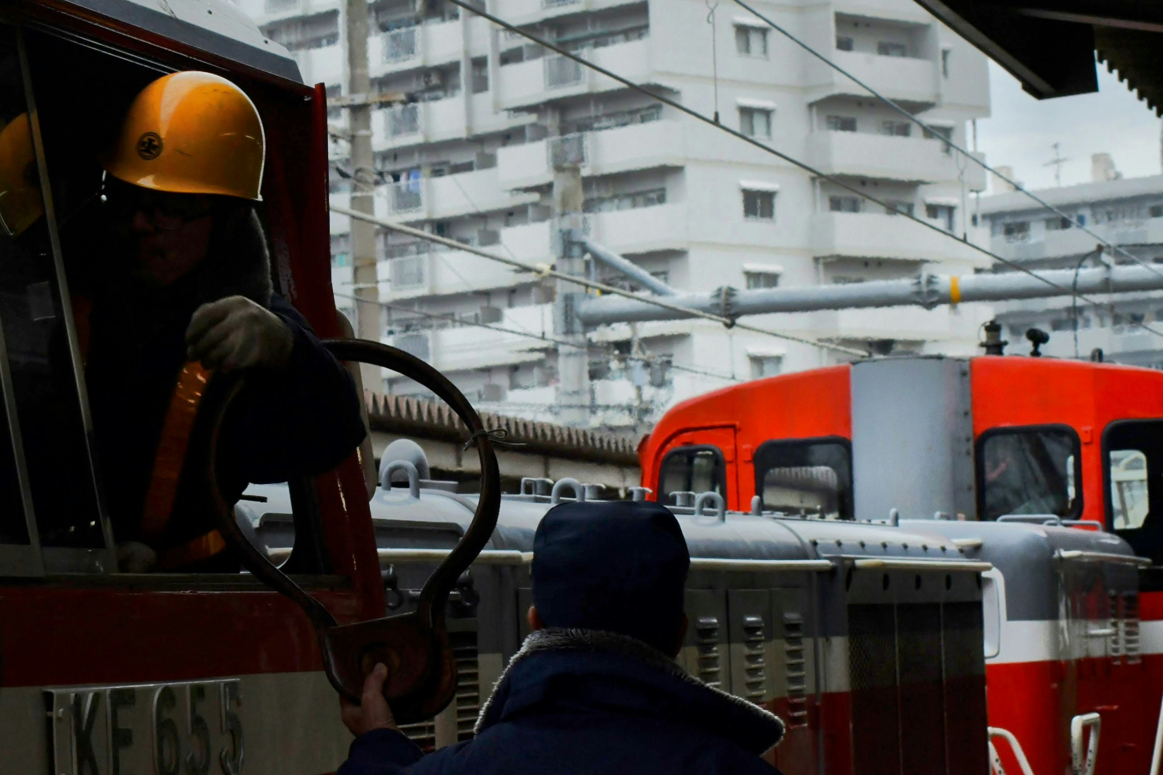 Operador de tren en una estación con una locomotora roja