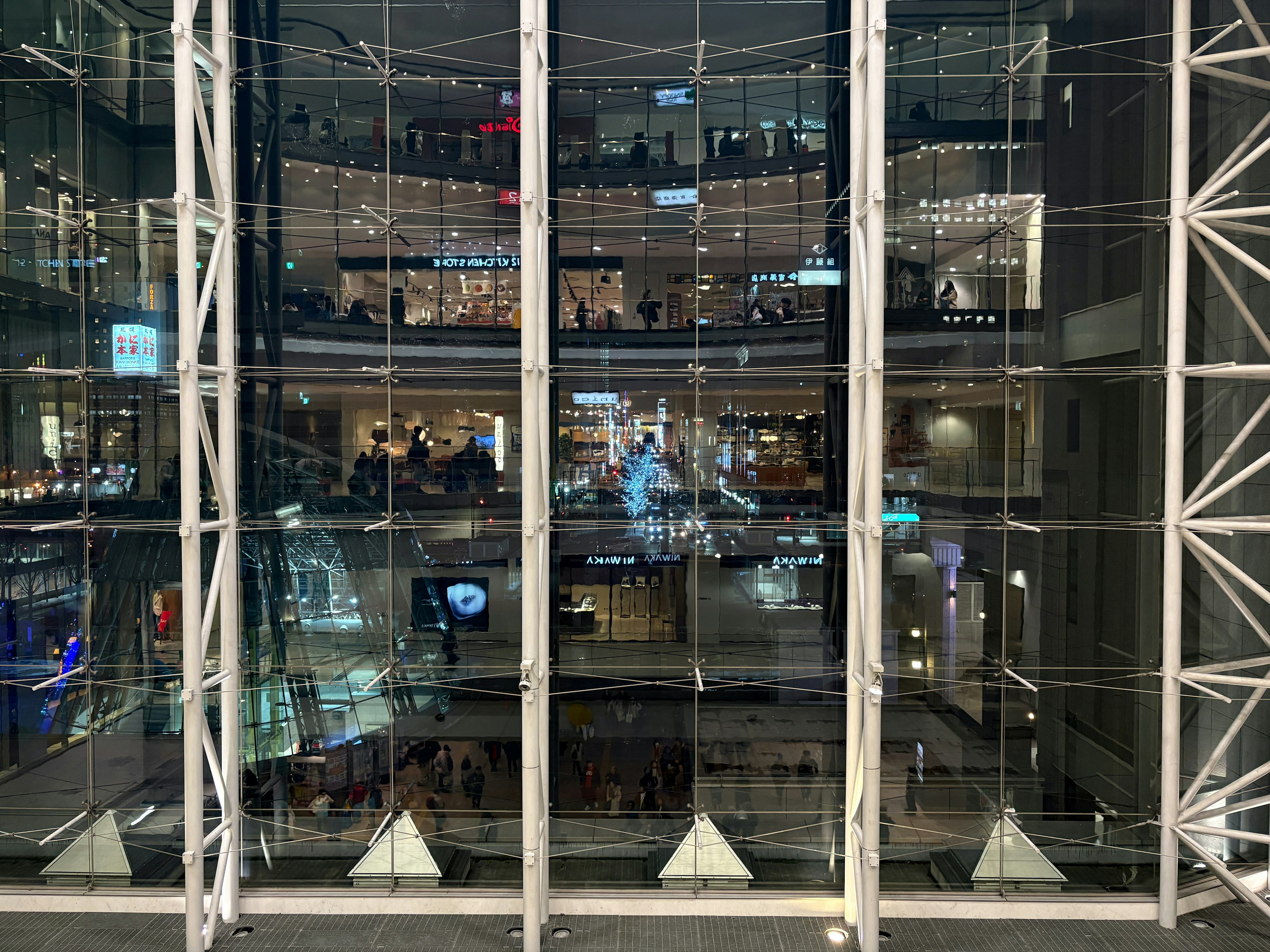 Vista interna di un edificio moderno con facciata in vetro che riflette luci