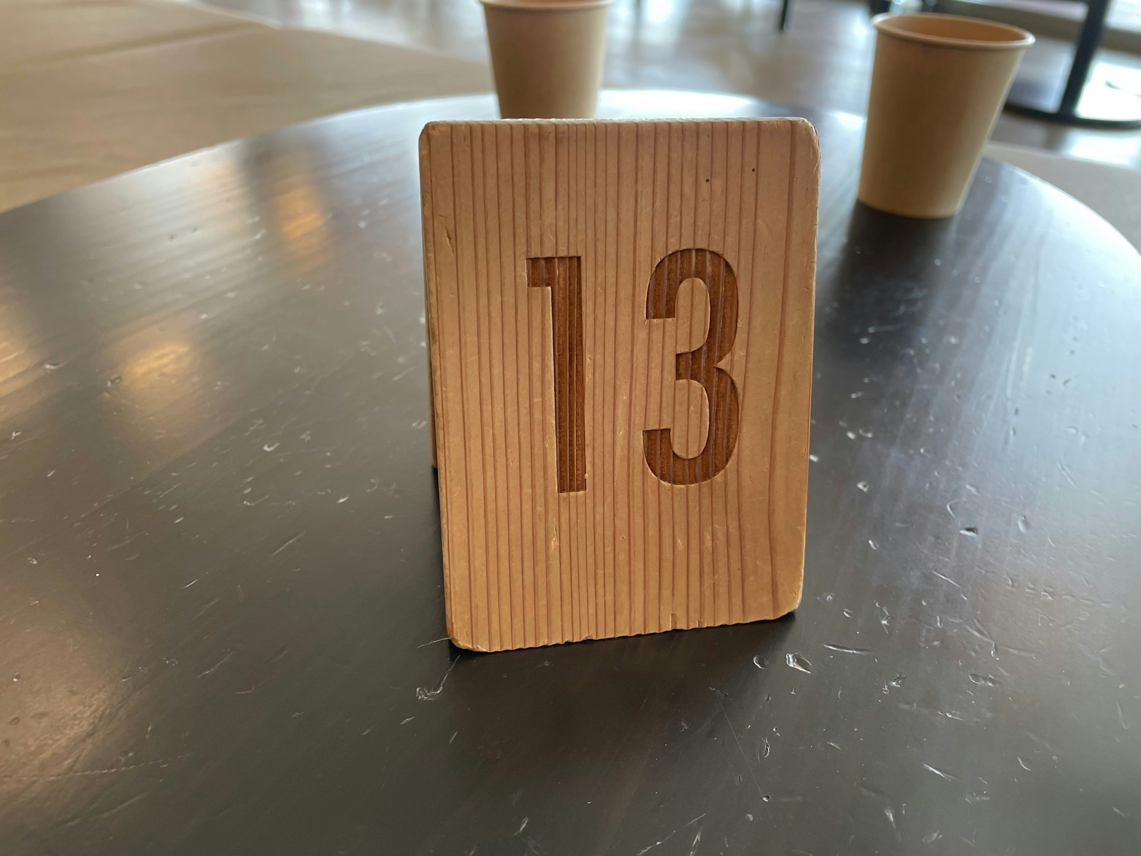 Wooden sign with number 13 placed on a table