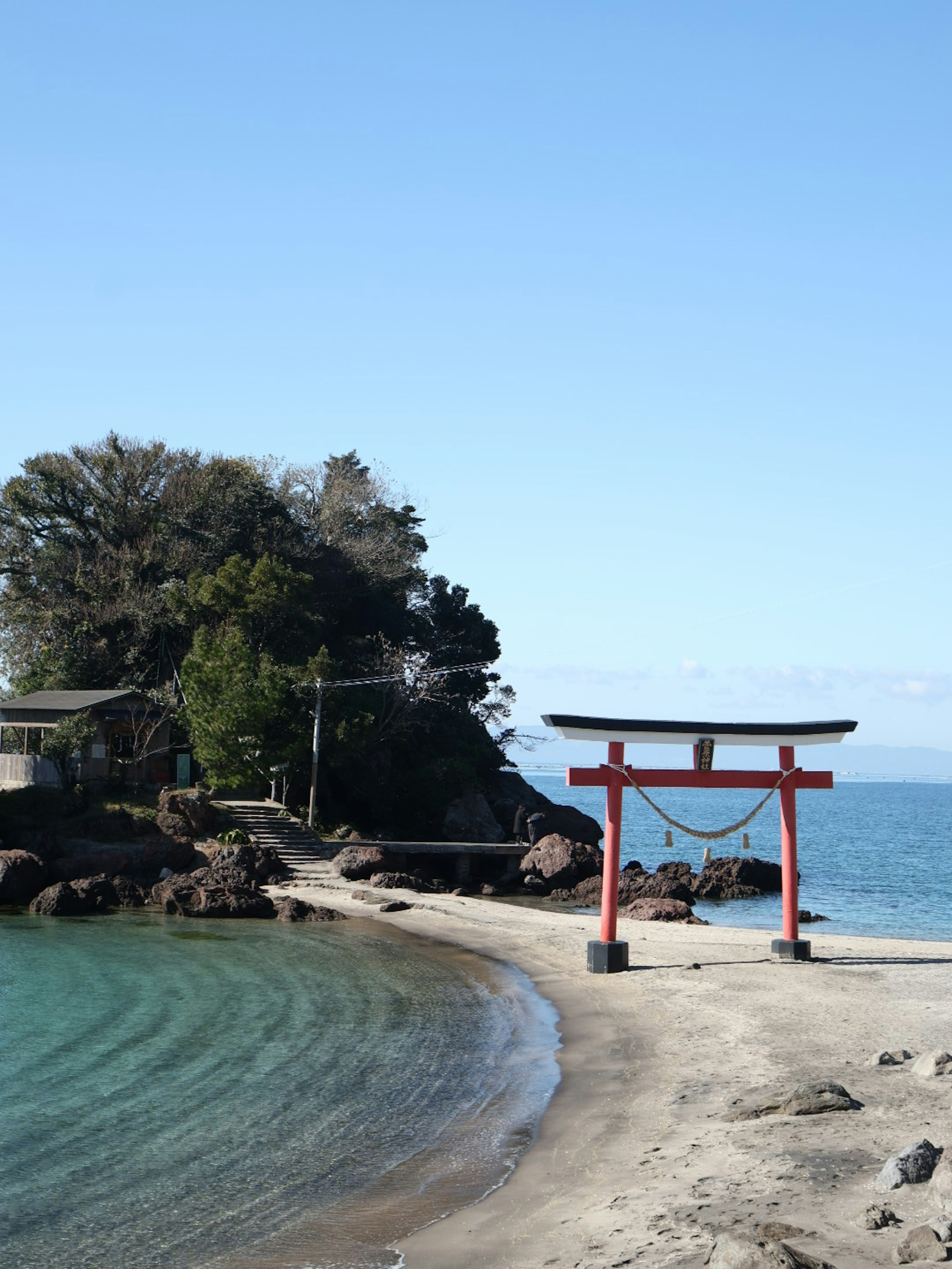 寧靜的藍色海洋和海灘旁的紅色鳥居的風景