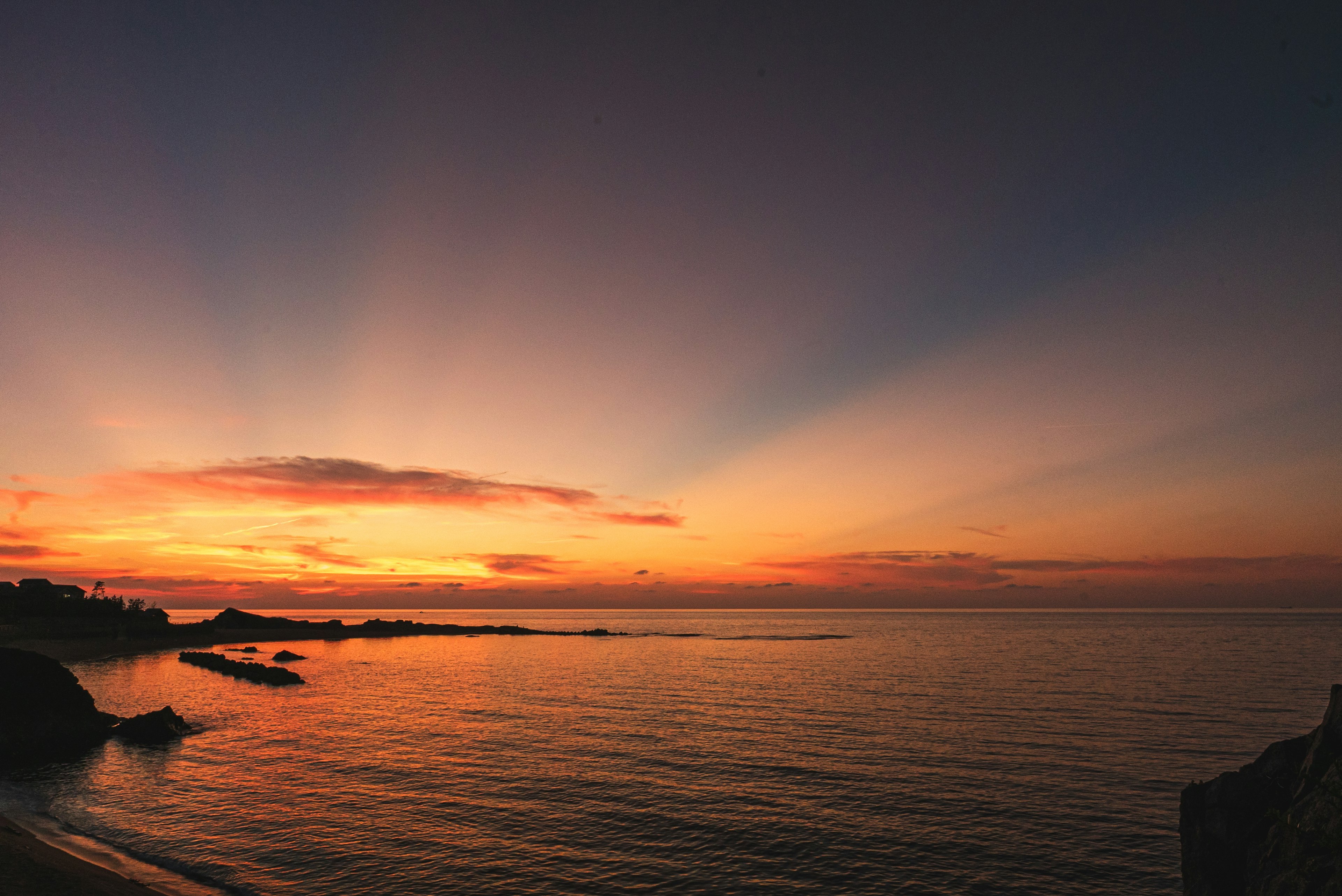 Schöner Sonnenuntergang über ruhigen Ozeanwassern mit Lichtstrahlen