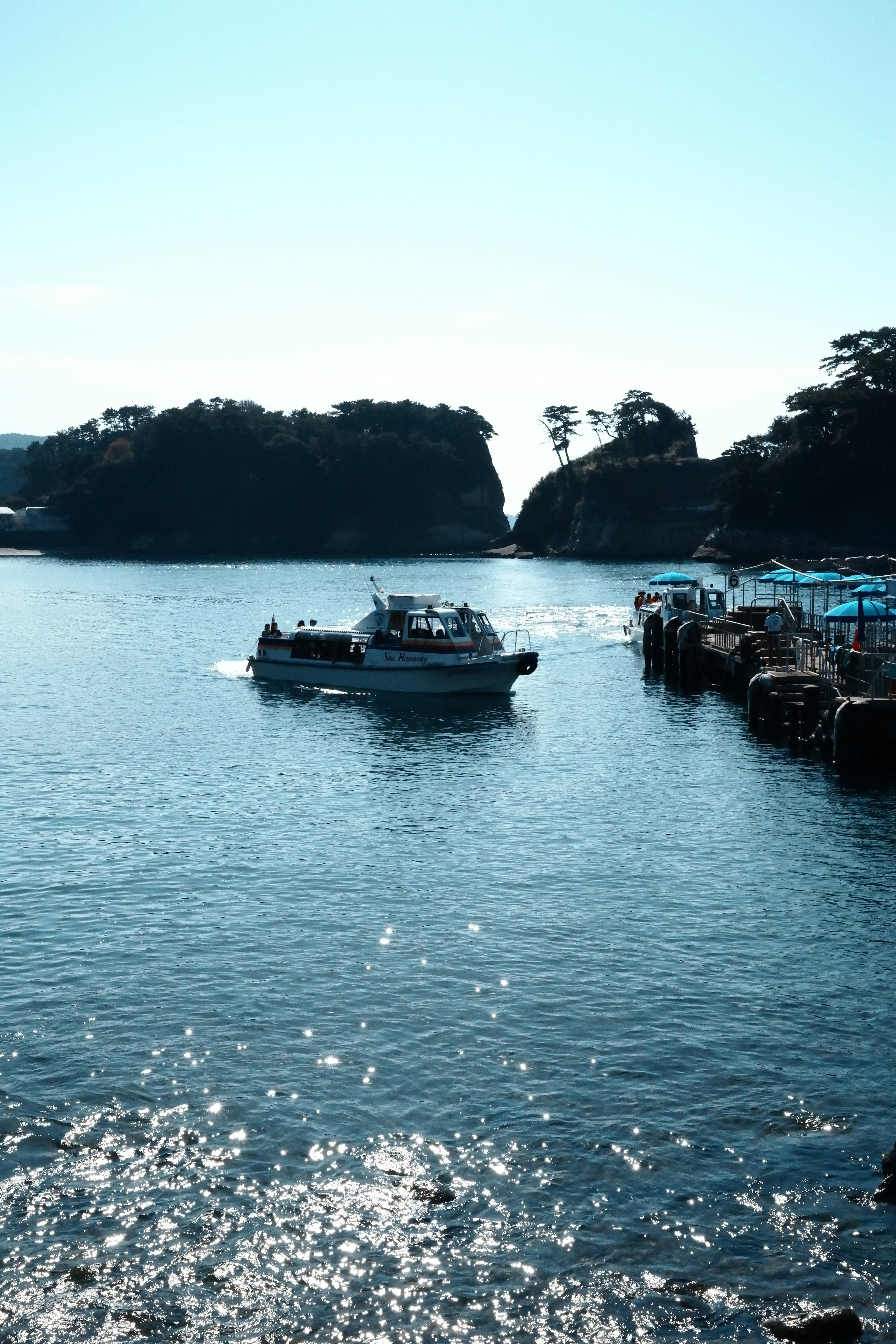 青い海に浮かぶボートと静かな島々の風景