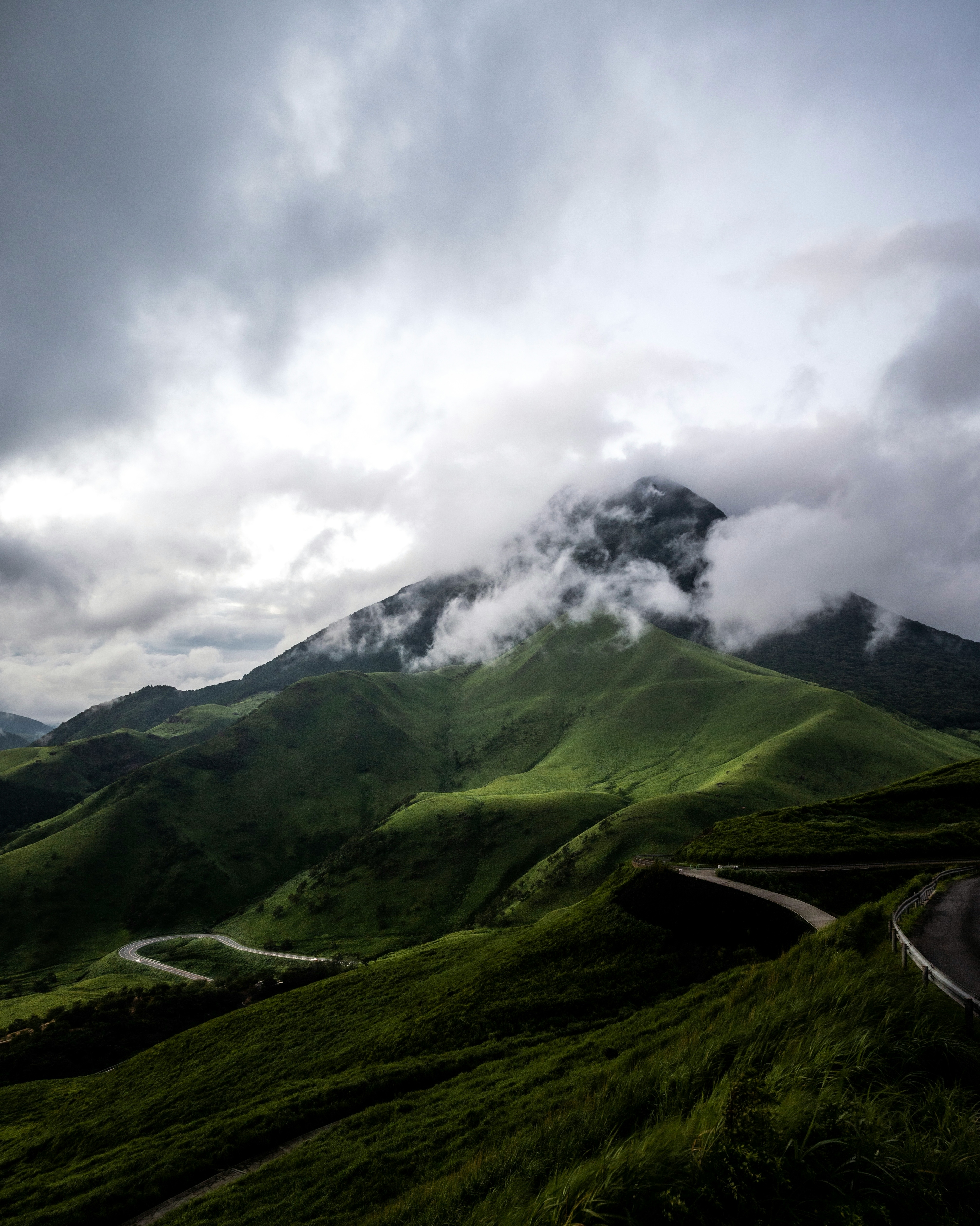 緑豊かな山々と雲に覆われた山頂の風景