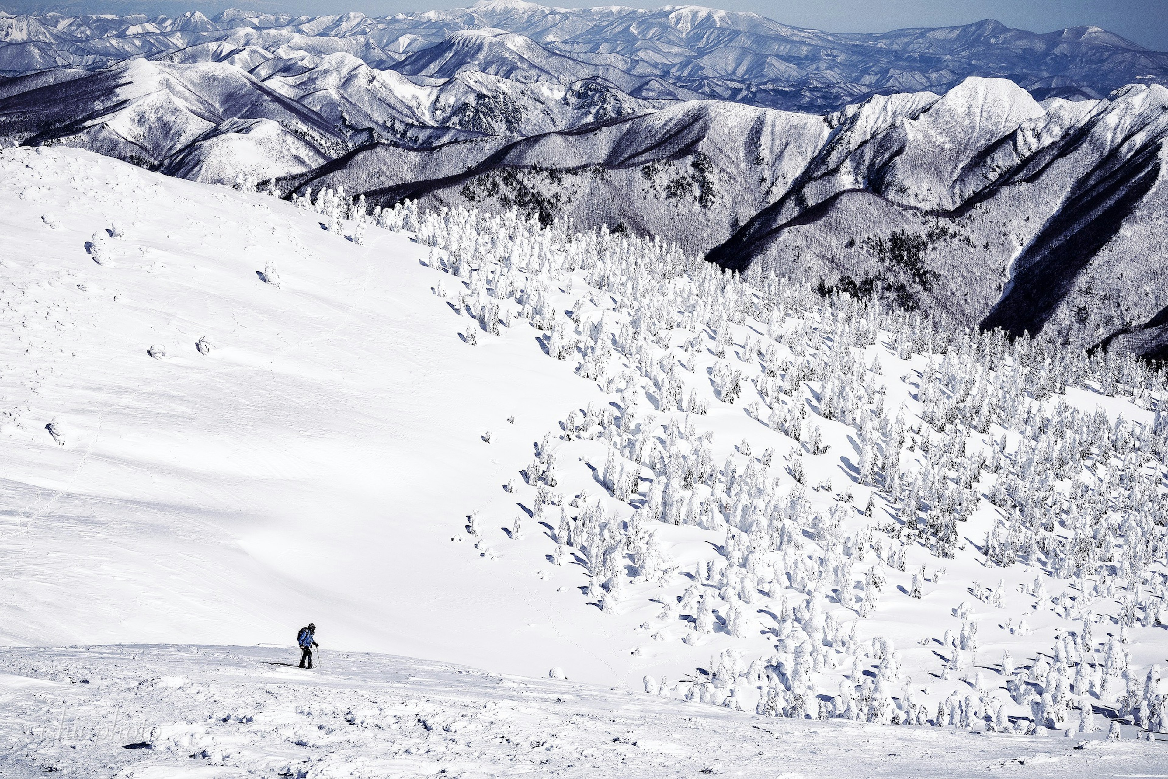 Schneebedeckte Berge mit einem Skifahrer im Vordergrund