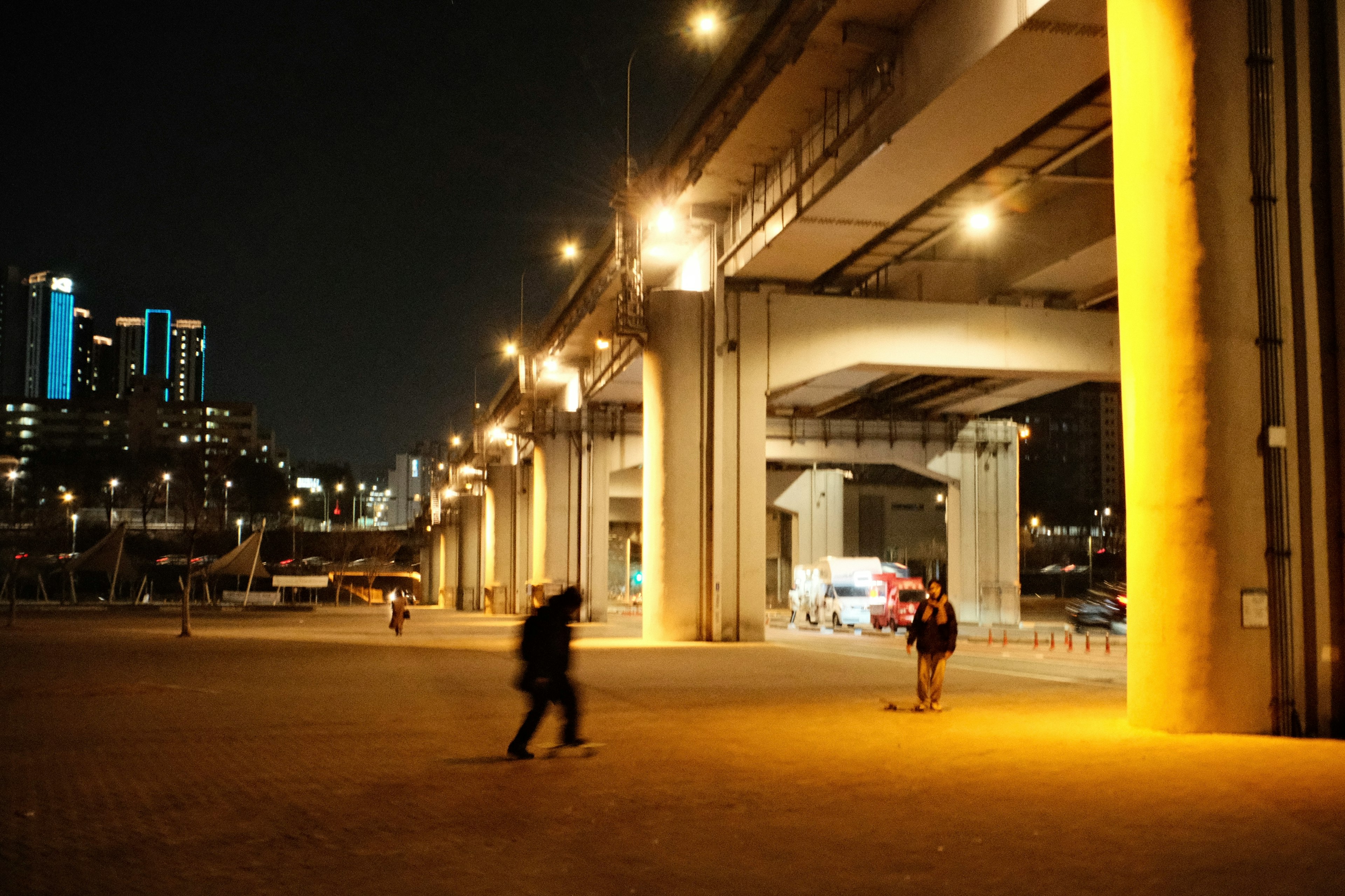 夜の都市風景 高速道路の下に立つ人々 ビルの明かりが映える