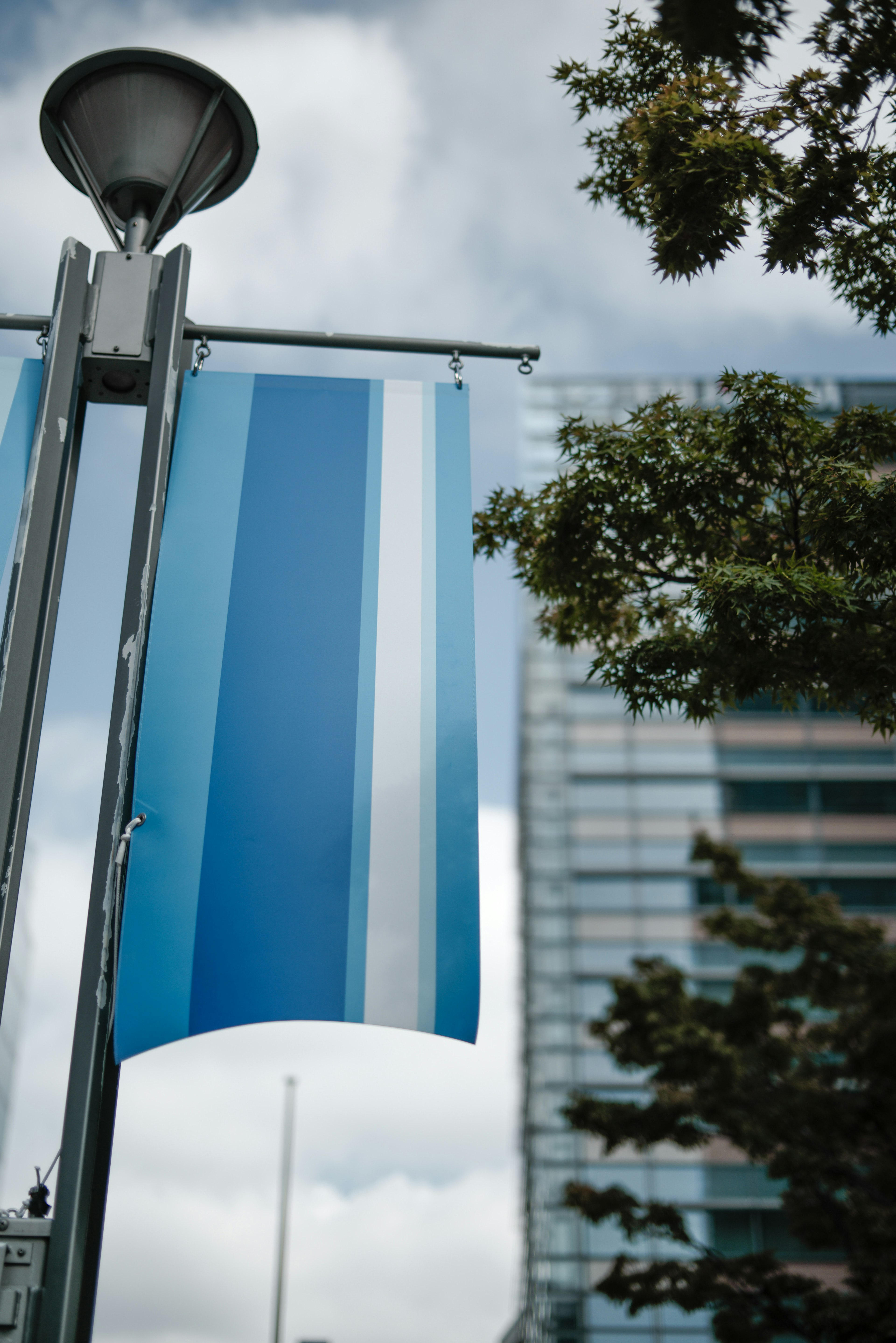 Blue striped flag hanging from a street lamp