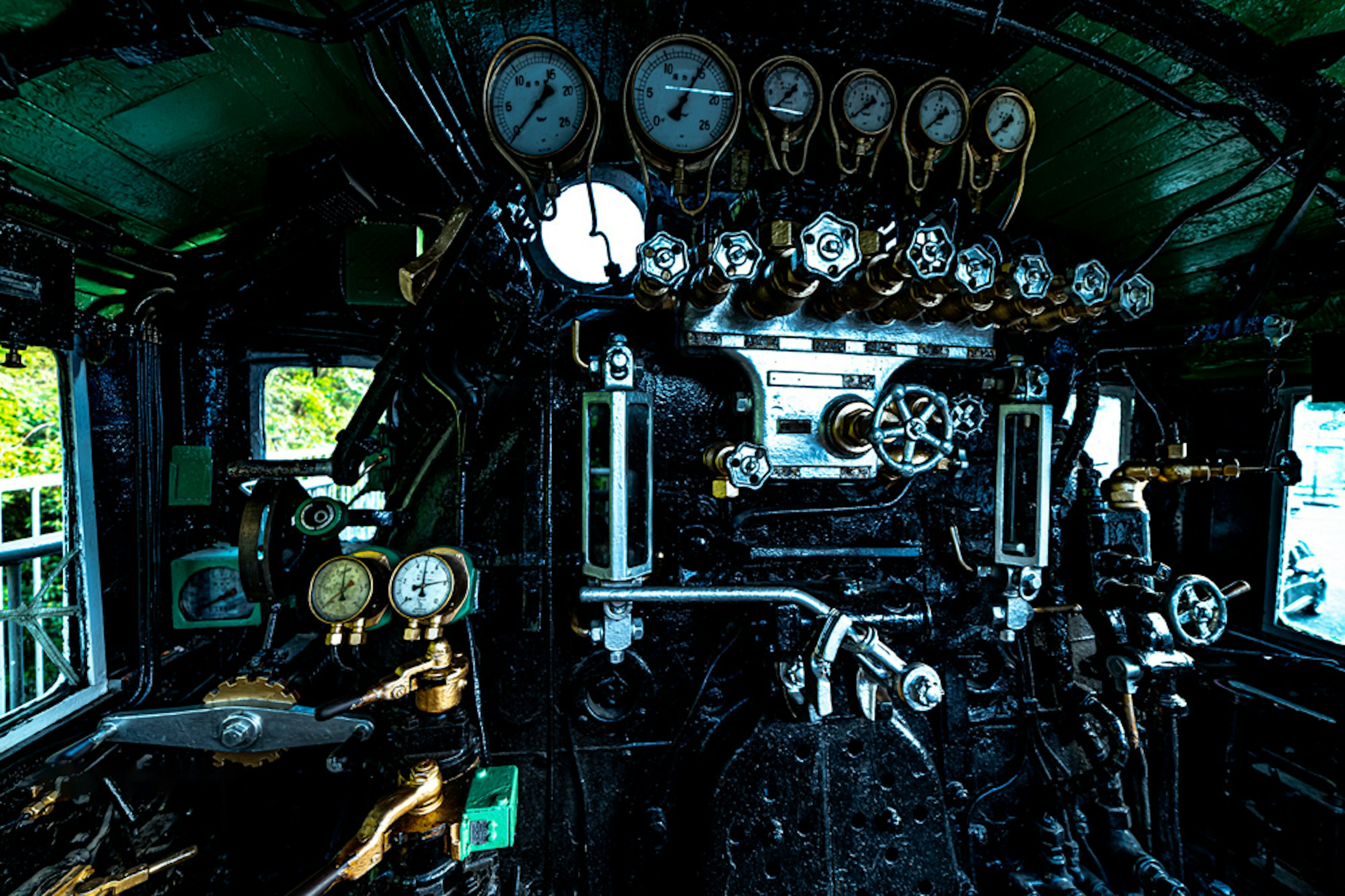 Interno di un cockpit di locomotiva a vapore con vari manometri e leve