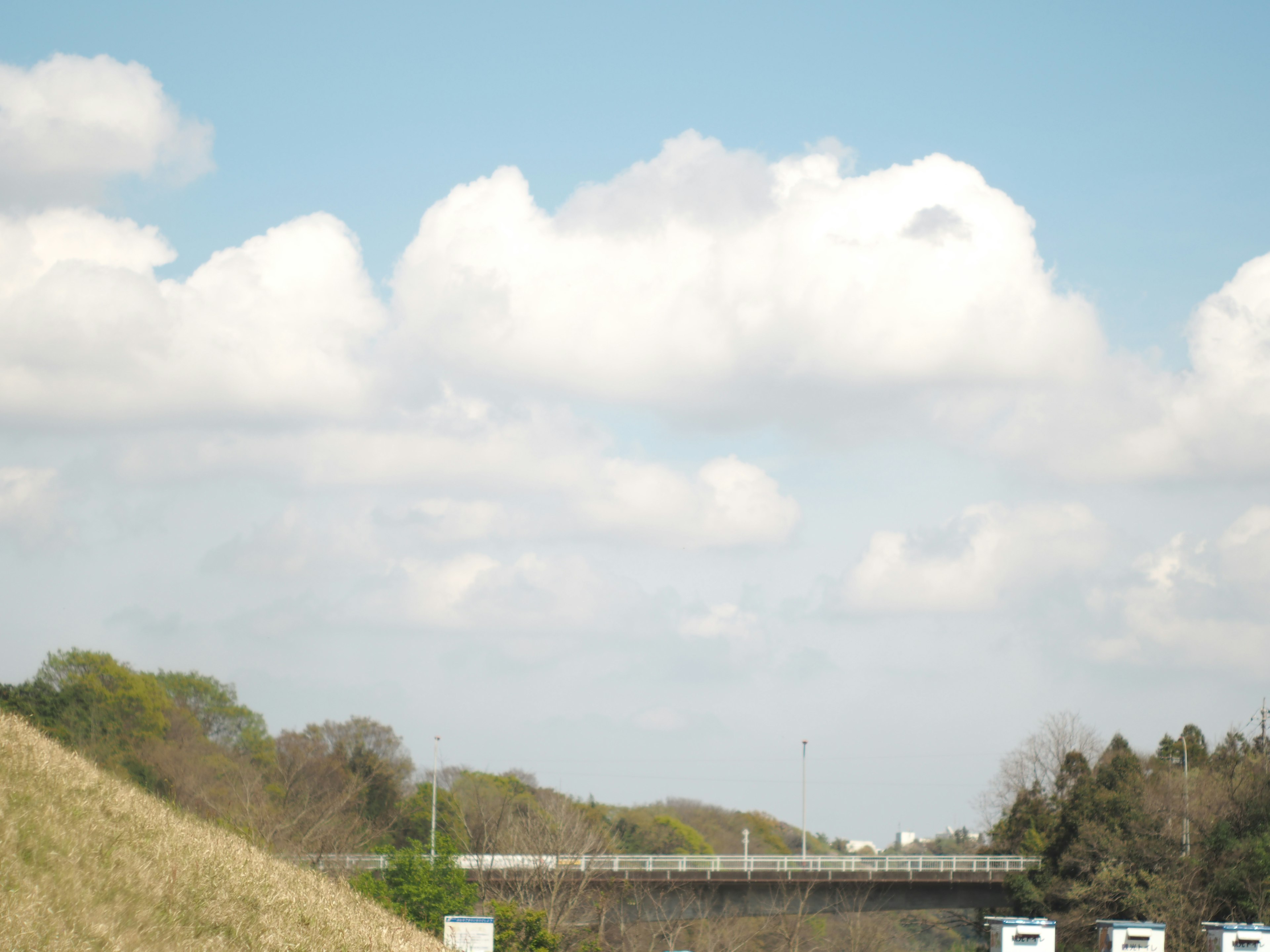 Vista panoramica di un ponte sotto un cielo blu con nuvole bianche soffici