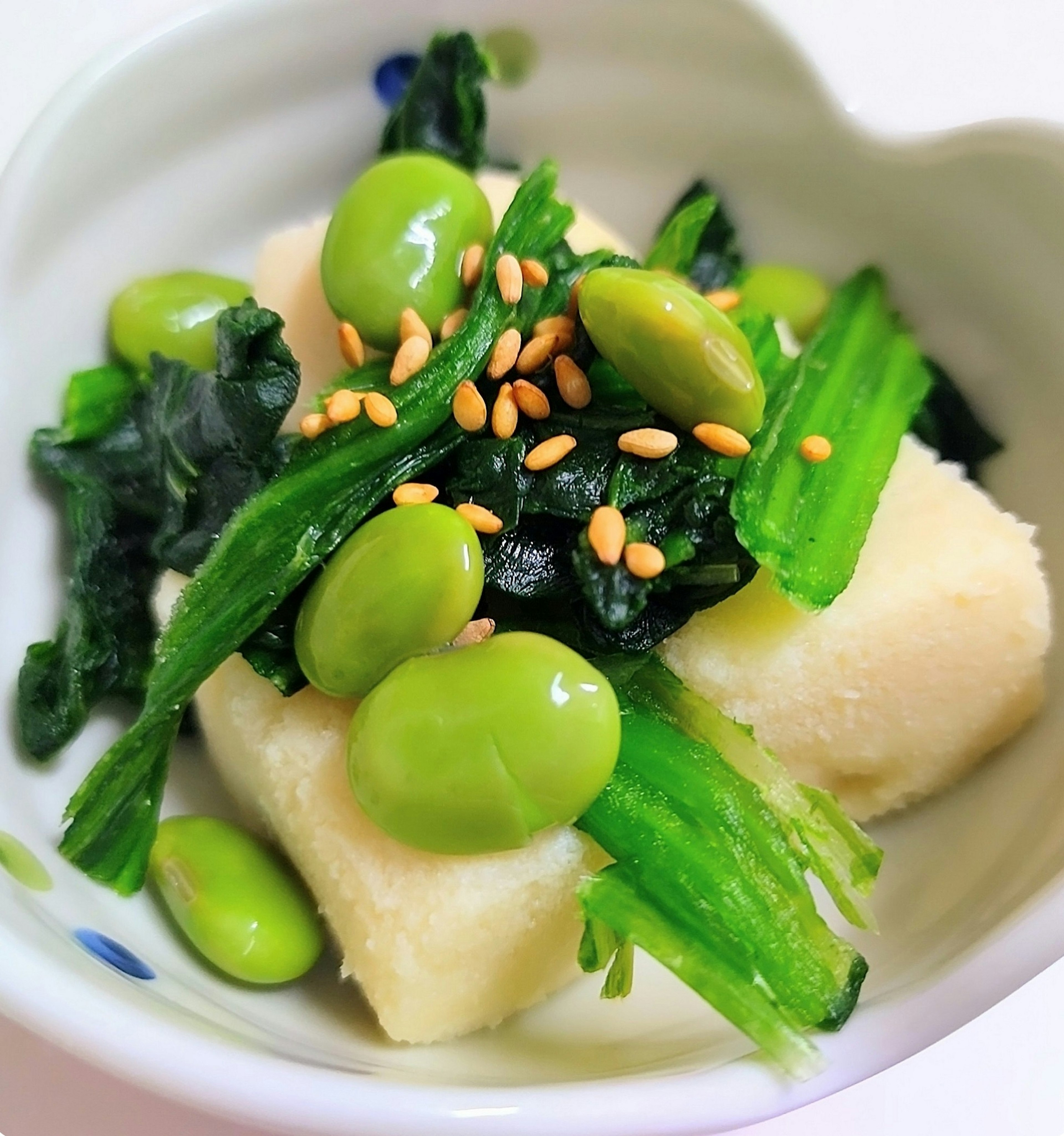 Tofu dish topped with green vegetables and beans