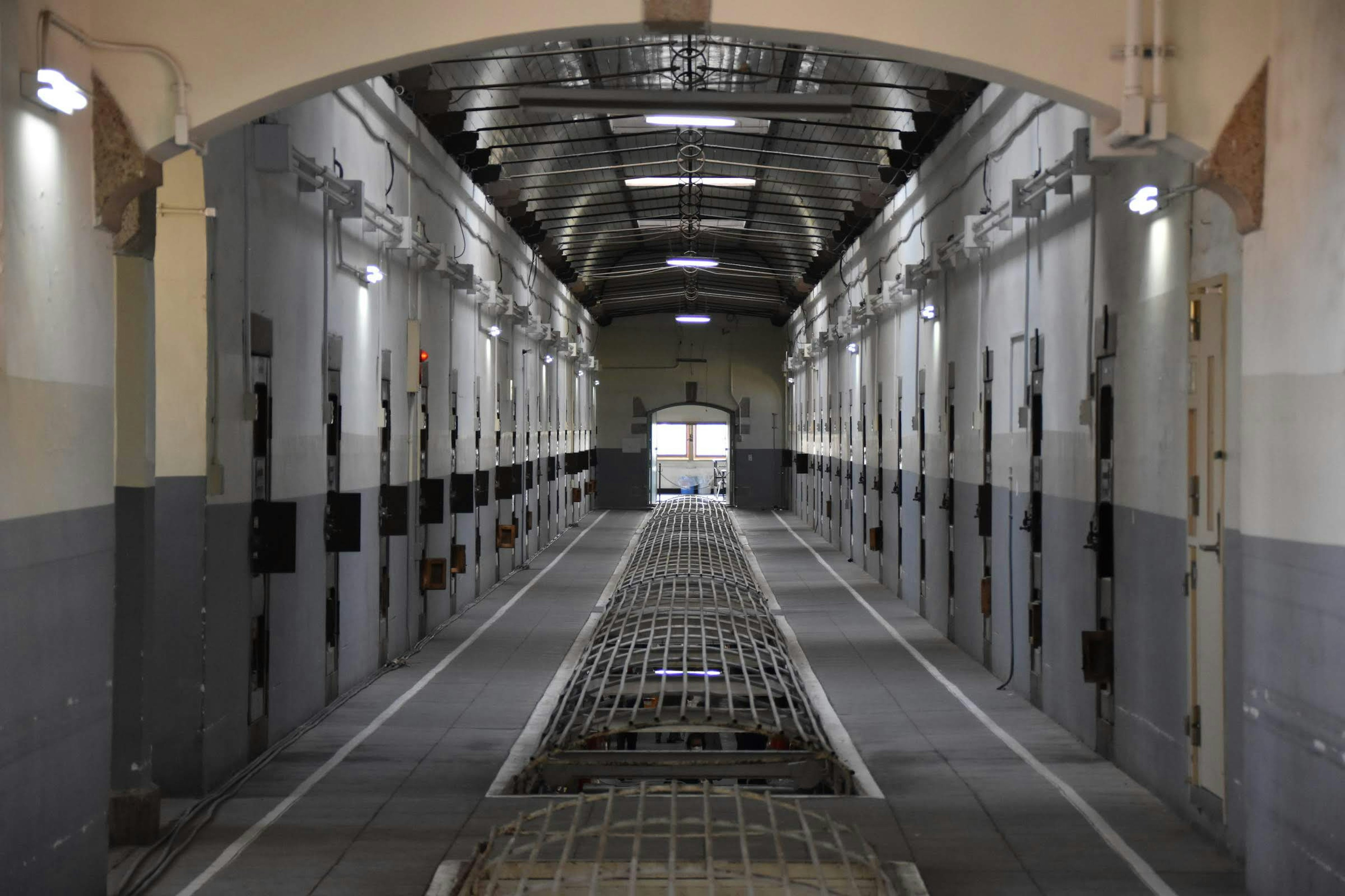 Interior view of a prison corridor with individual cells