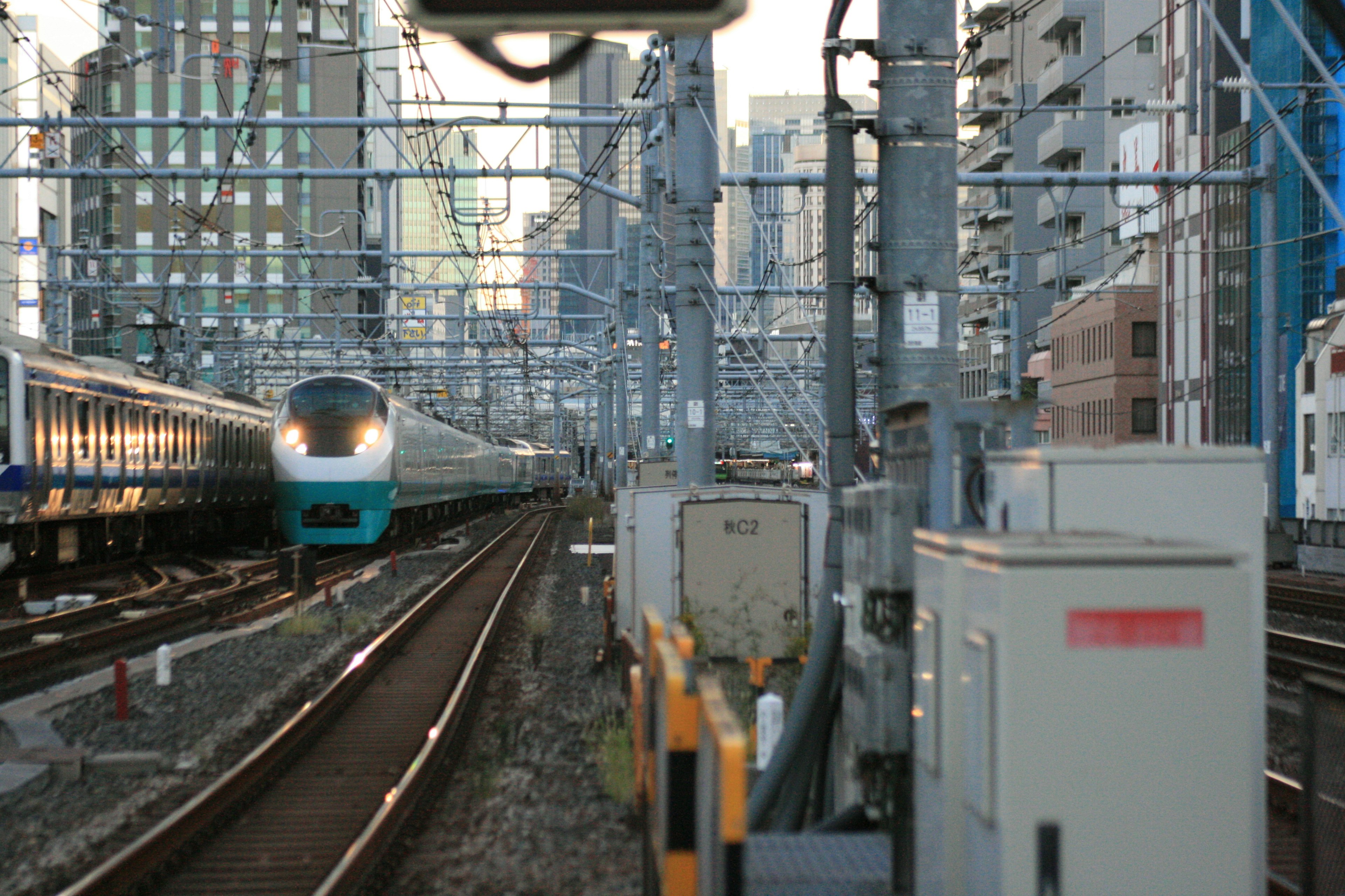 鉄道の線路と都市のビルが並ぶ風景に停車中の列車