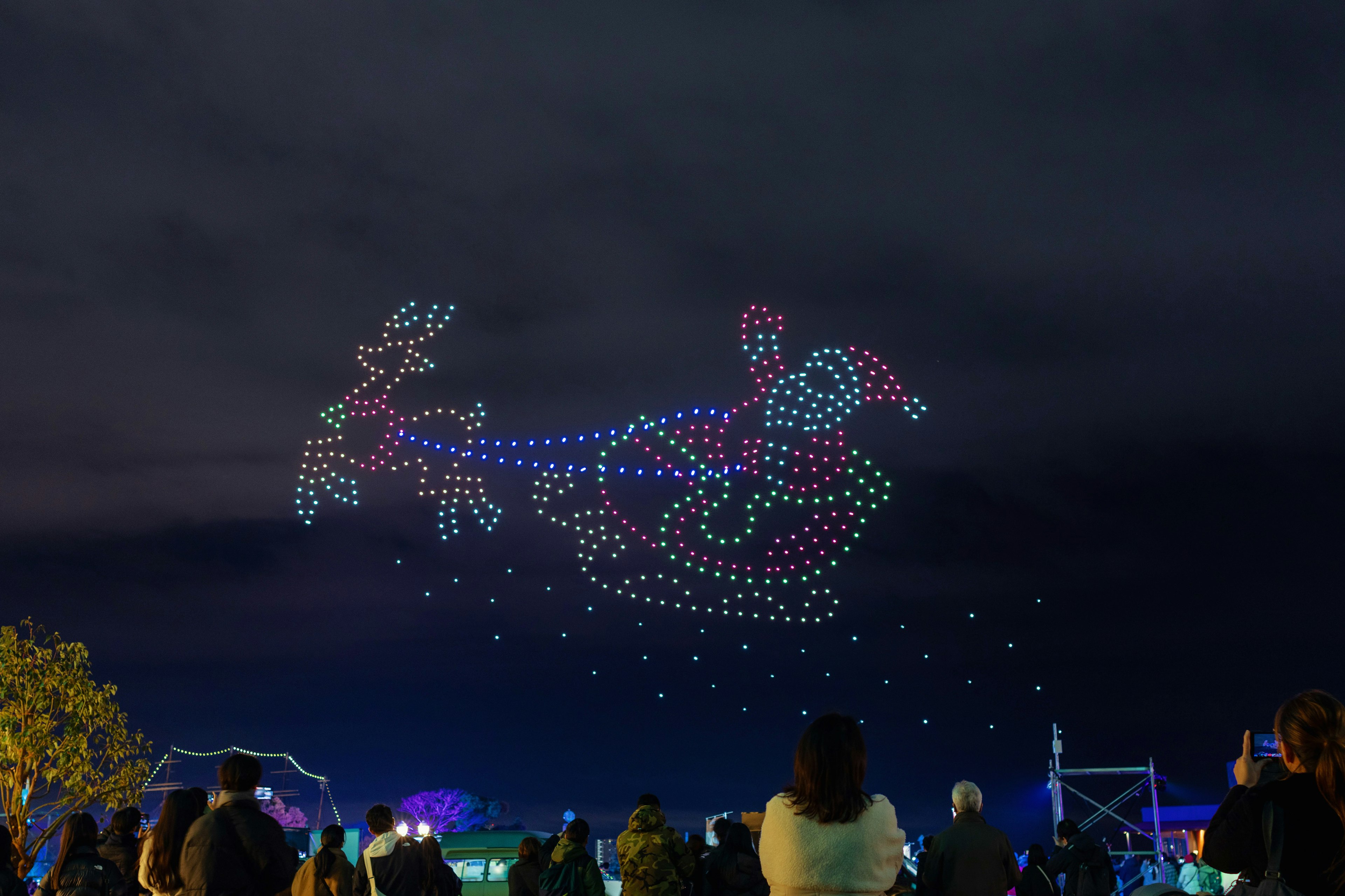 Un magnifique spectacle de lumière représentant le Père Noël et un renne illuminé dans le ciel nocturne