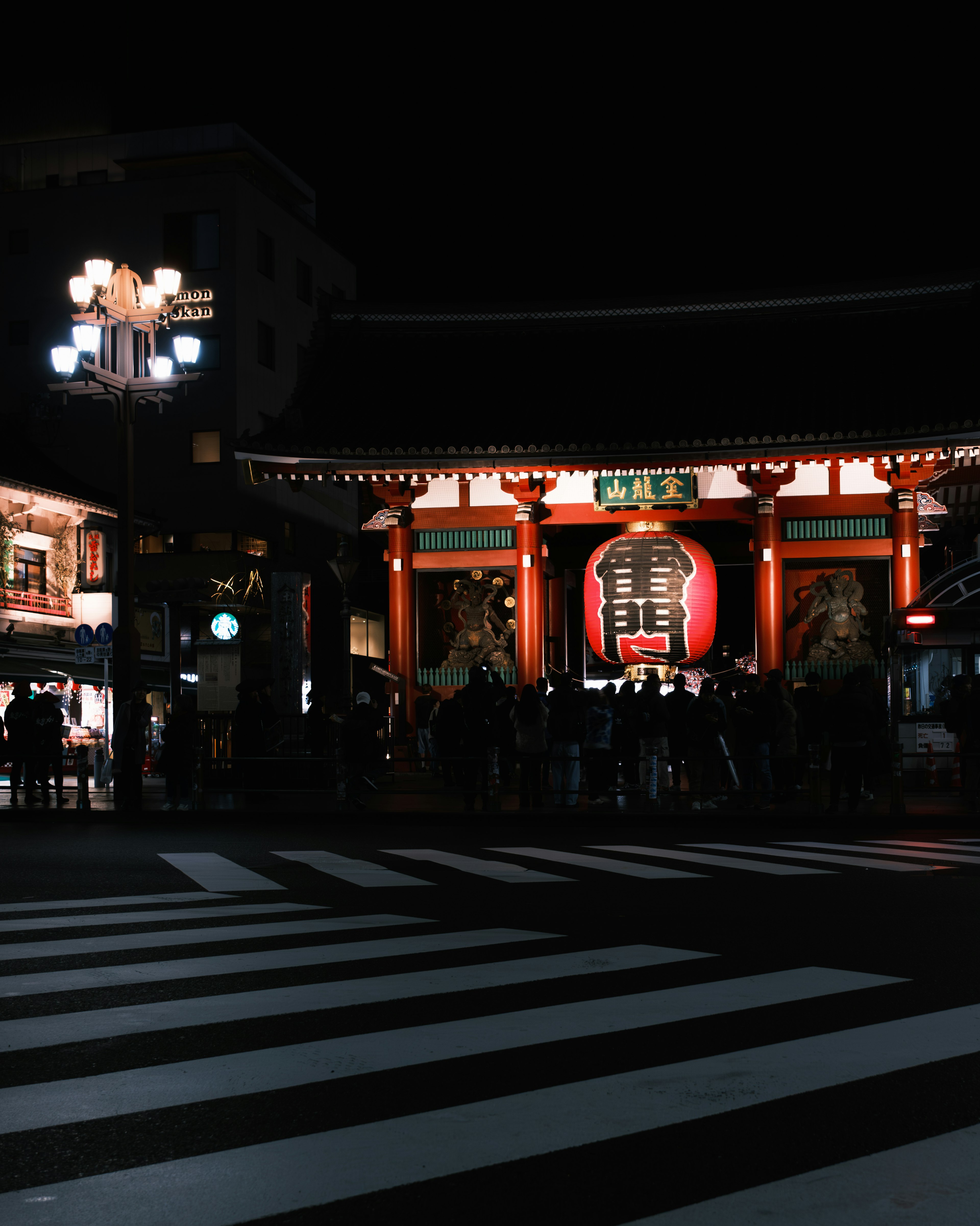 夜の浅草寺の赤い門と人々が集まる様子